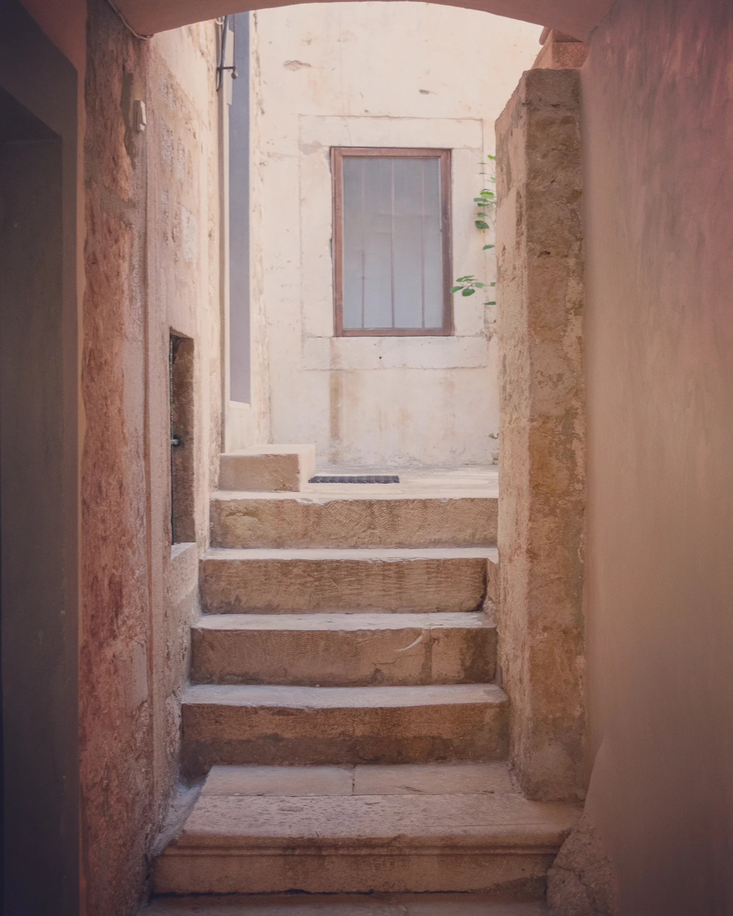 Small stairway in Dubrovnik’s Old Town framed by stone walls and soft sunlight.
