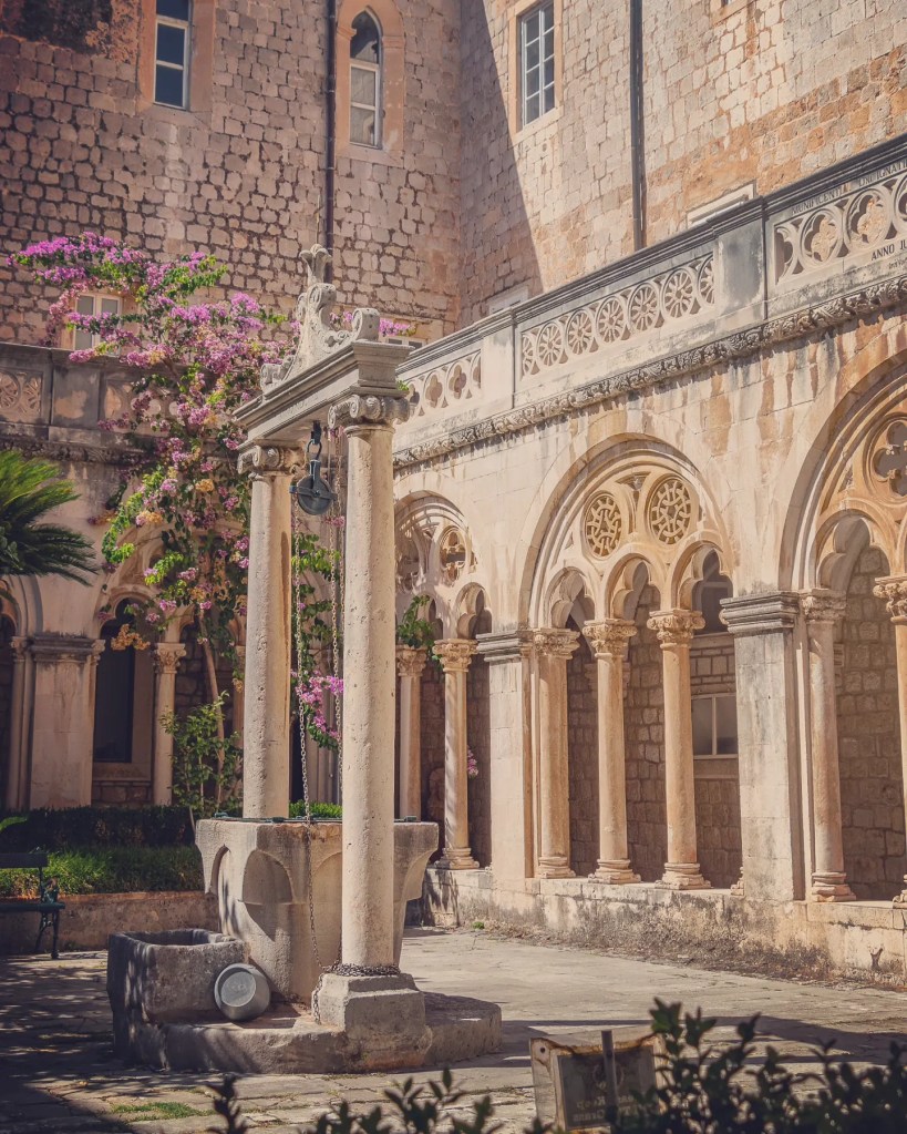 Stone well and flowering vines in the courtyard of the Dominican Monastery in Dubrovnik.