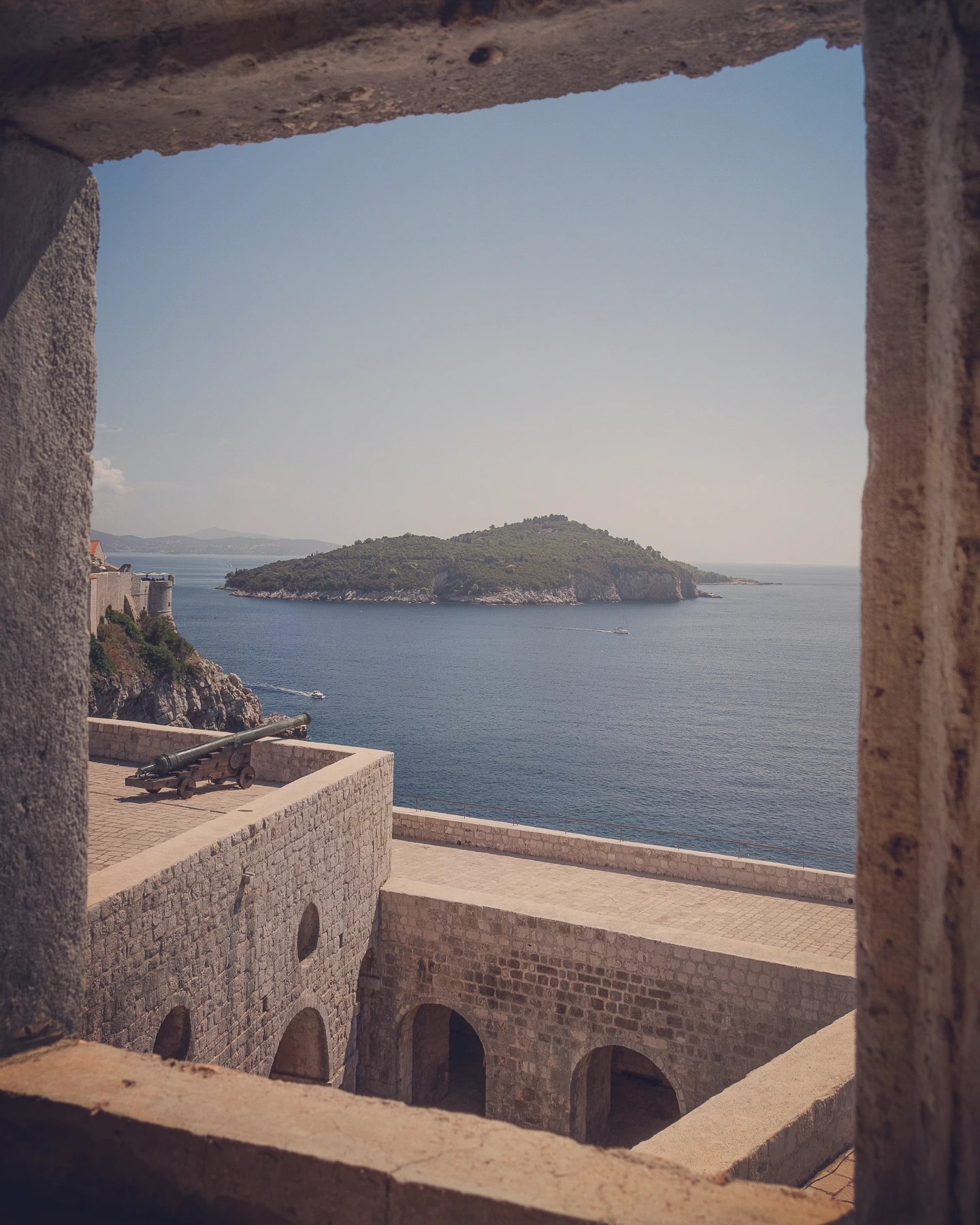 View of Lokrum Island framed by the walls of Fort Lovrijenac in Dubrovnik.