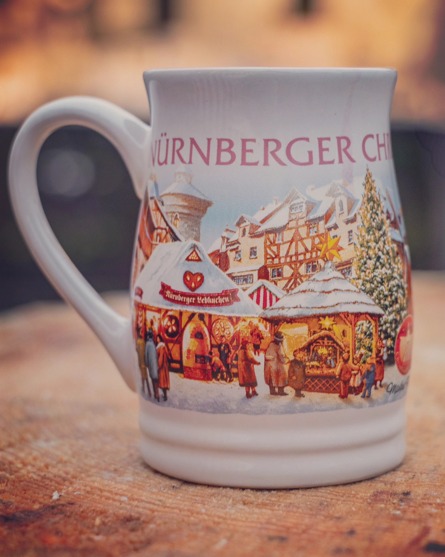 Decorative Nuremberg Christkindlesmarkt mug featuring winter scenes of market stalls and half-timbered houses.