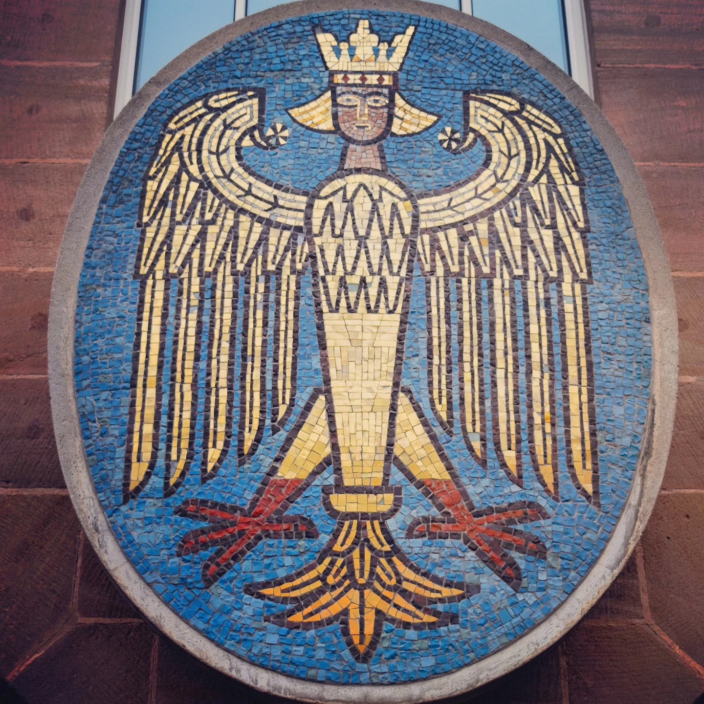 Colorful mosaic of Nuremberg’s crowned eagle coat of arms displayed on a building facade.