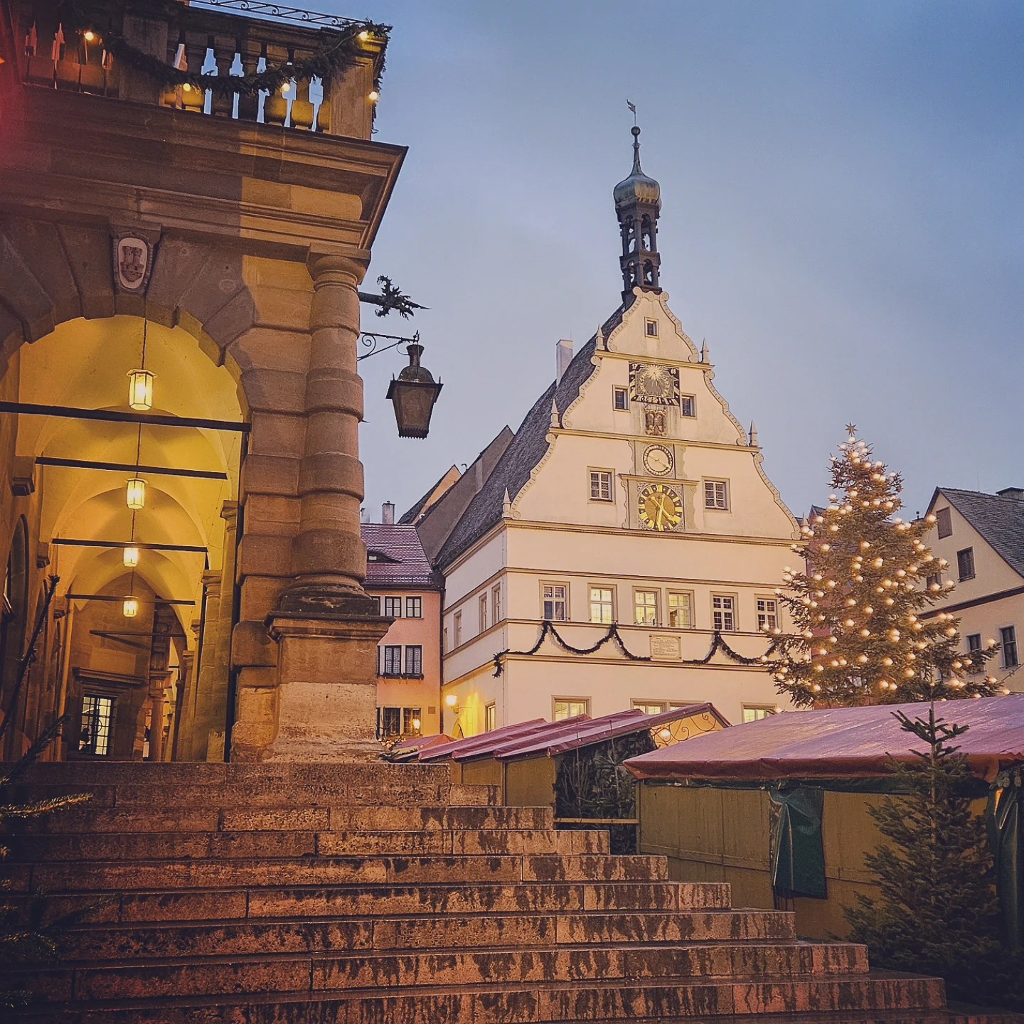 View of Rothenburg Town Hall and Christmas Market stalls from the stone steps beneath the arcade.
