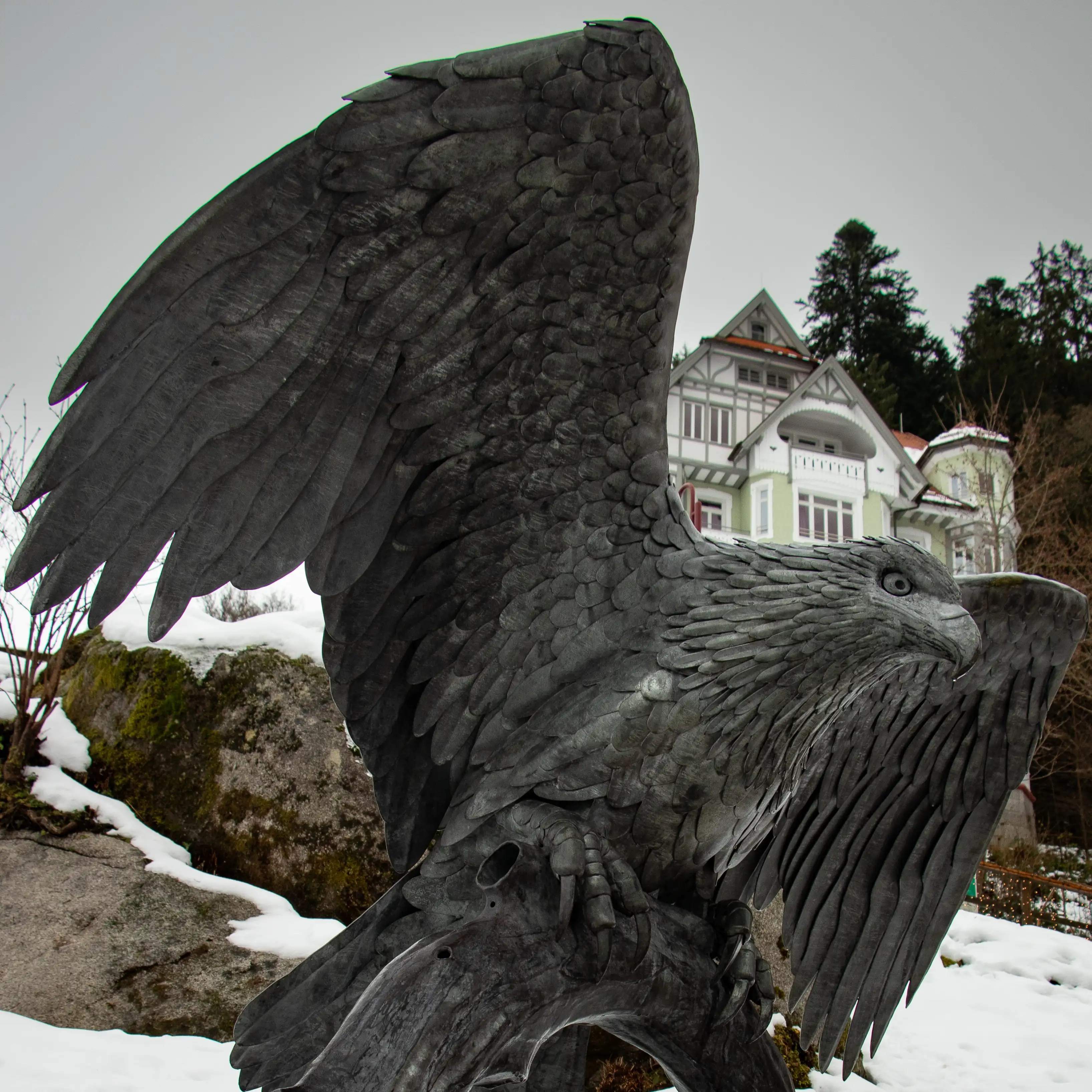 Detailed sculpture of a large eagle with wings spread wide, displayed outdoors in snowy Triberg.