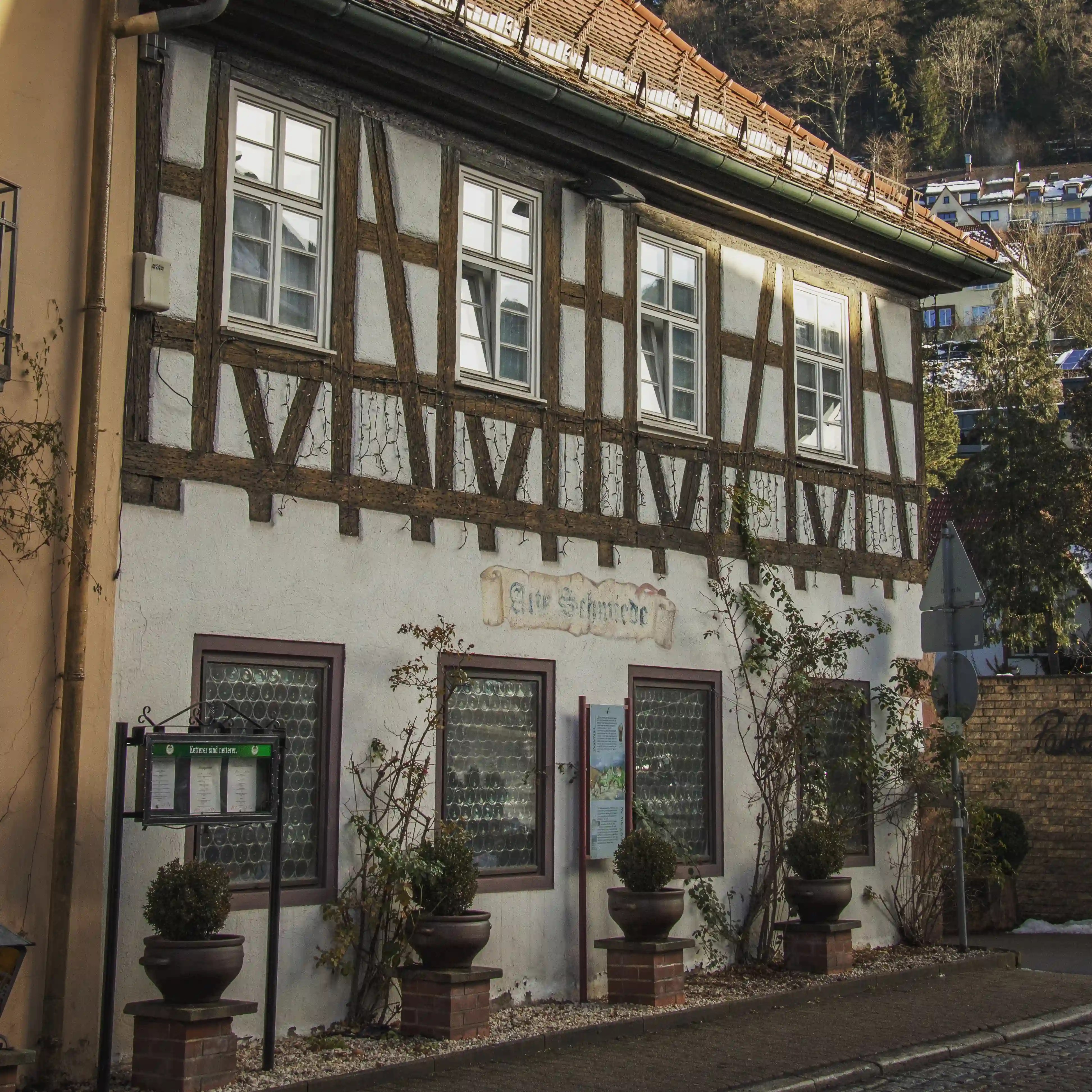 Traditional half-timbered house in Triberg with the sign “Alte Schmiede” above the windows.