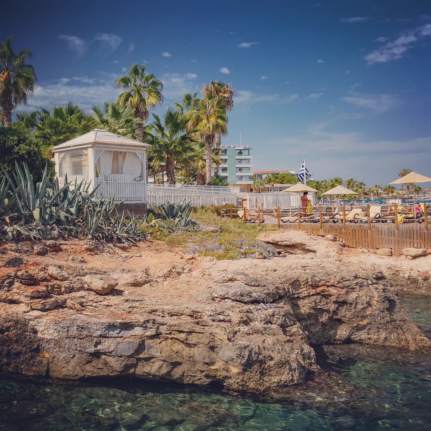 White cabana and beach area built above a rocky shoreline at Star Beach in Hersonissos.