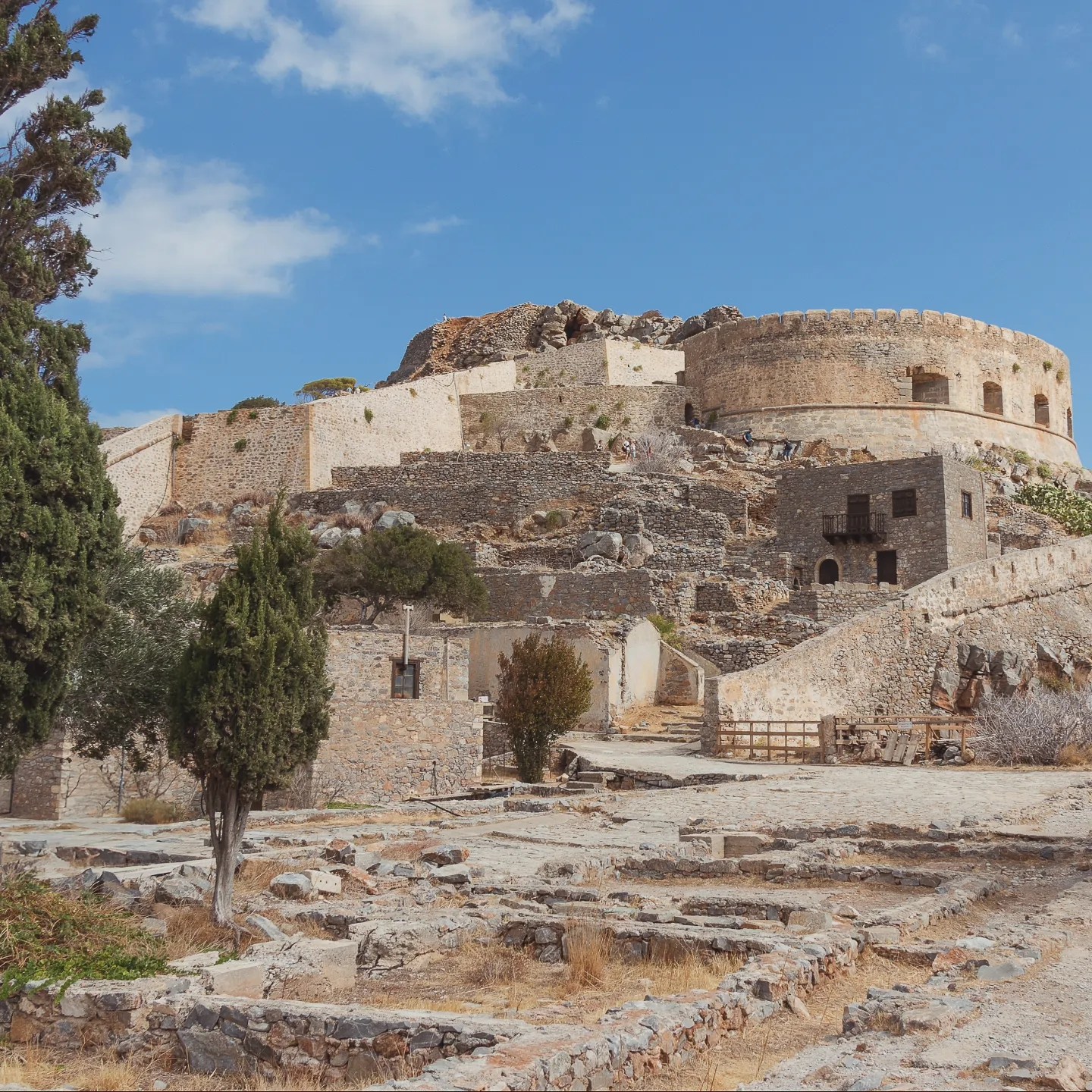 Stone ruins leading up to the large round Venetian bastion at the top of Spinalonga Island.