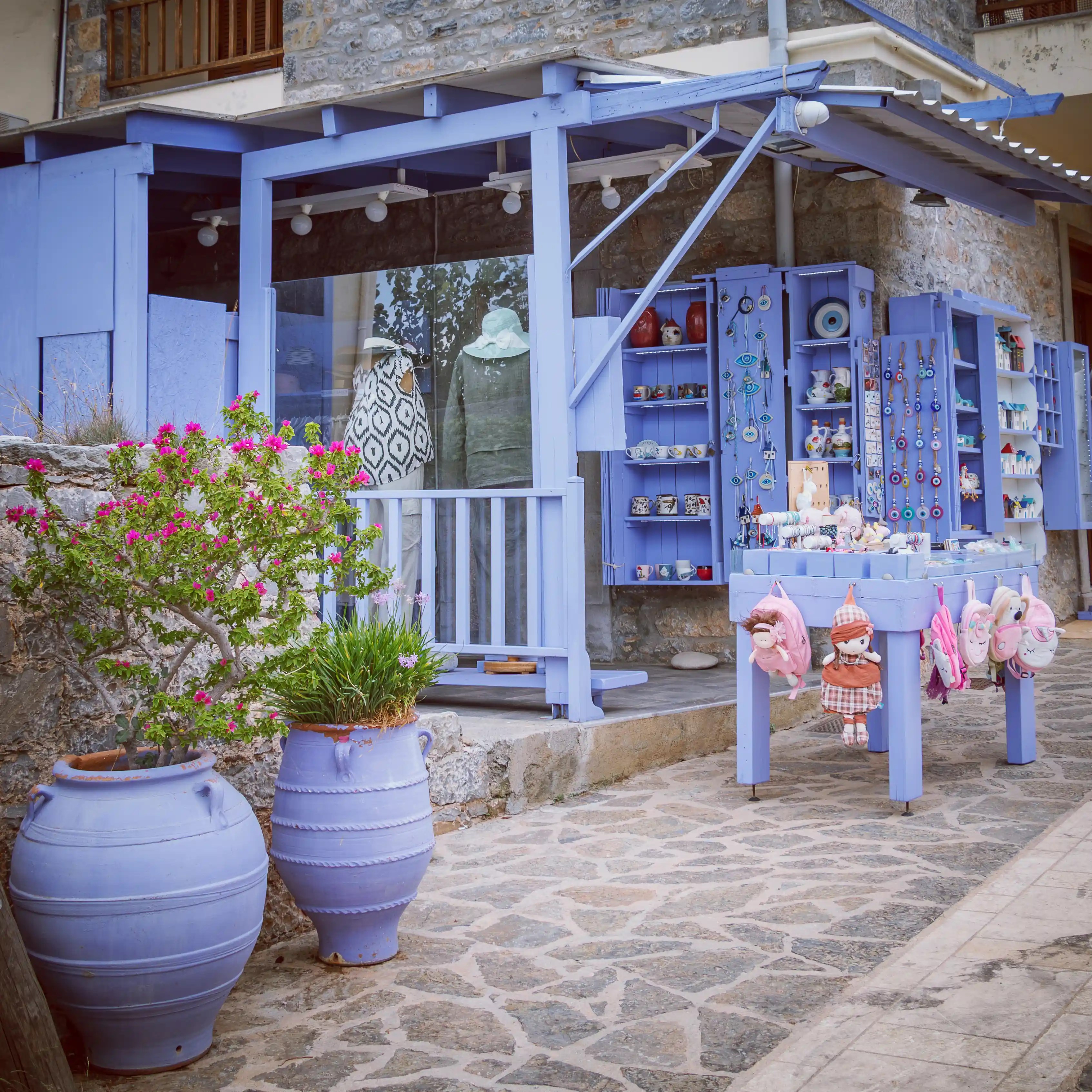 A lavender-painted gift shop in Plaka with shelves of handmade items, ceramics, and souvenirs.