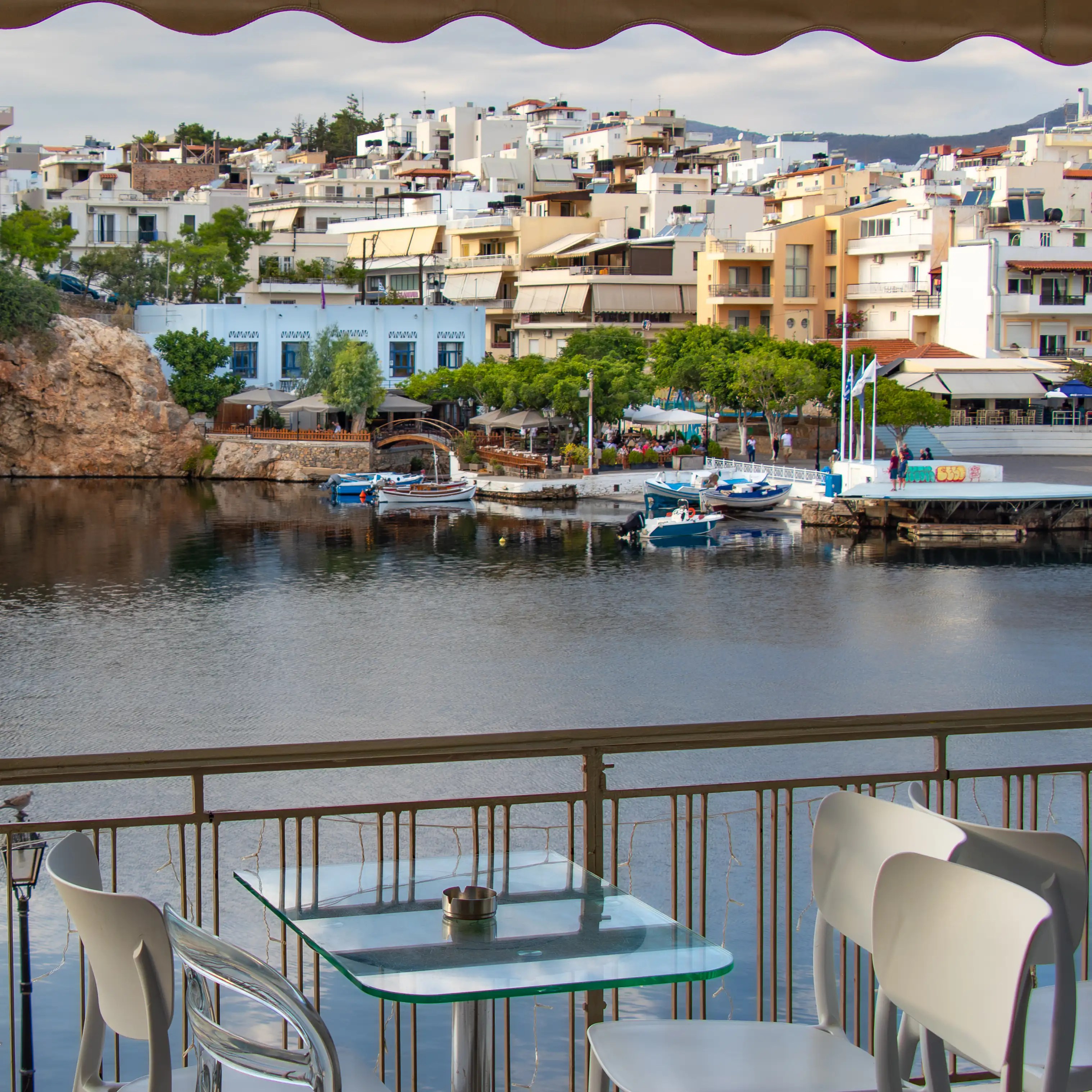 A balcony view overlooking Voulismeni Lake and the surrounding buildings in Agios Nikolaos.