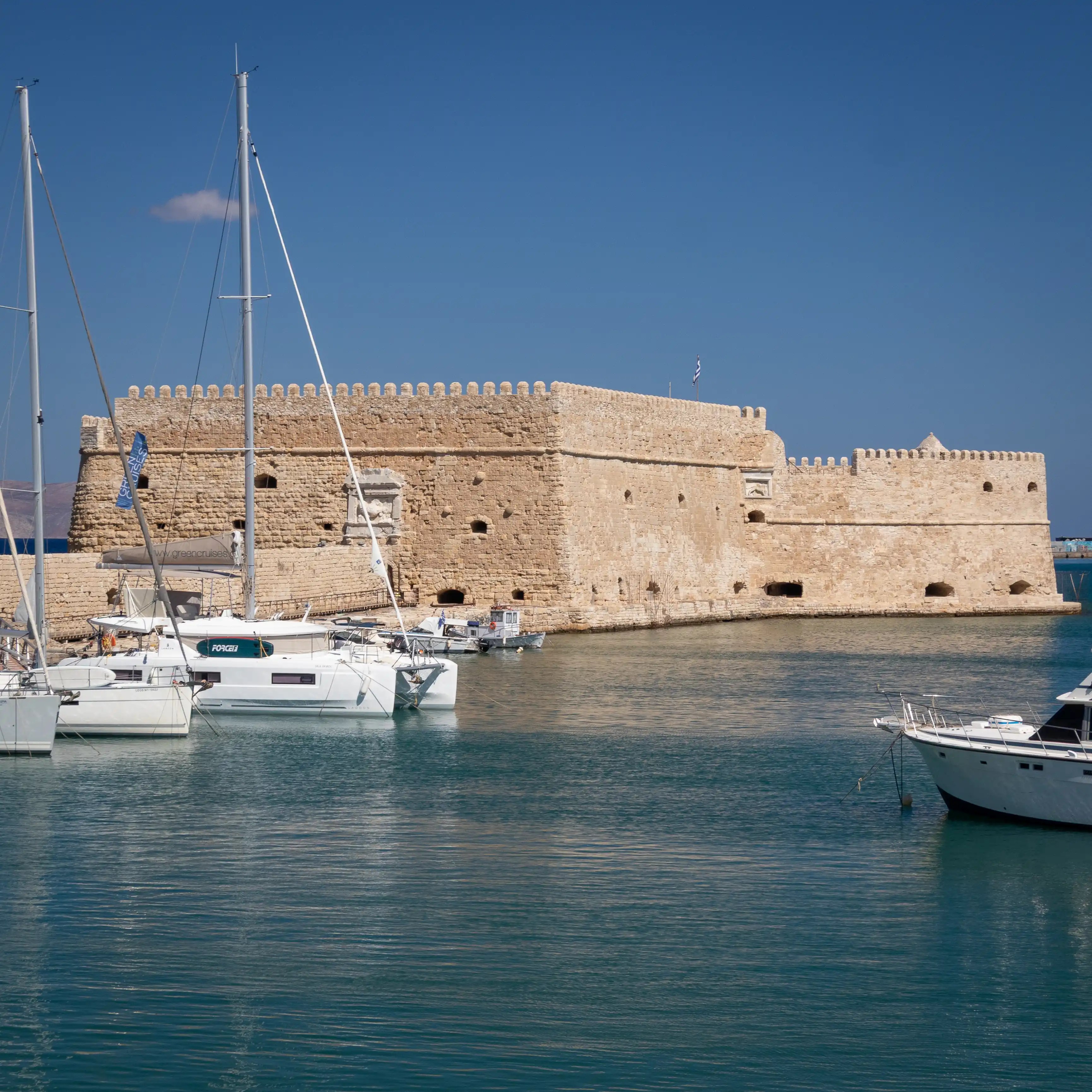 Venetian Koules Fortress at Heraklion harbor with boats docked in the foreground.