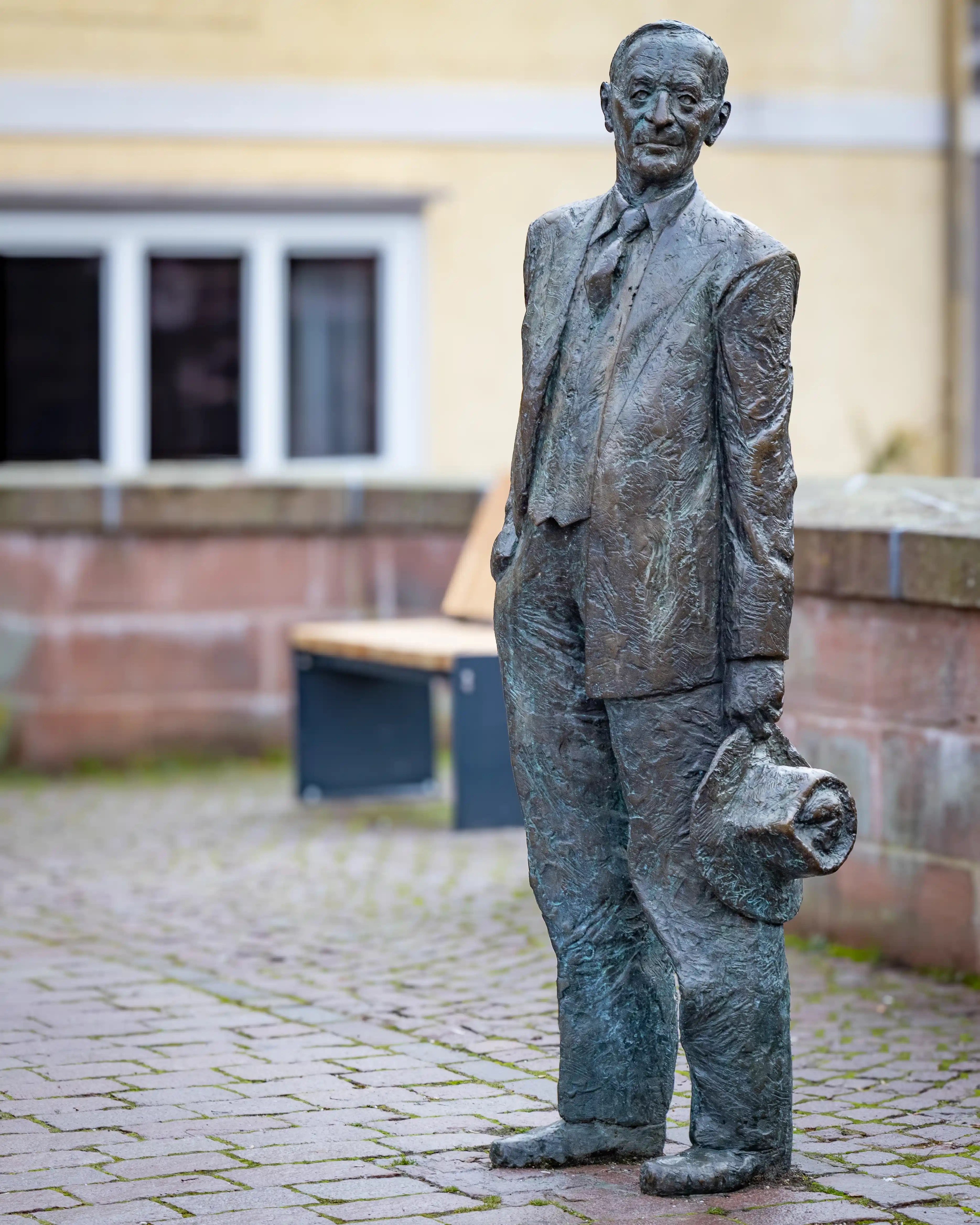 A bronze statue of Hermann Hesse stands on a brick bridge in Calw.