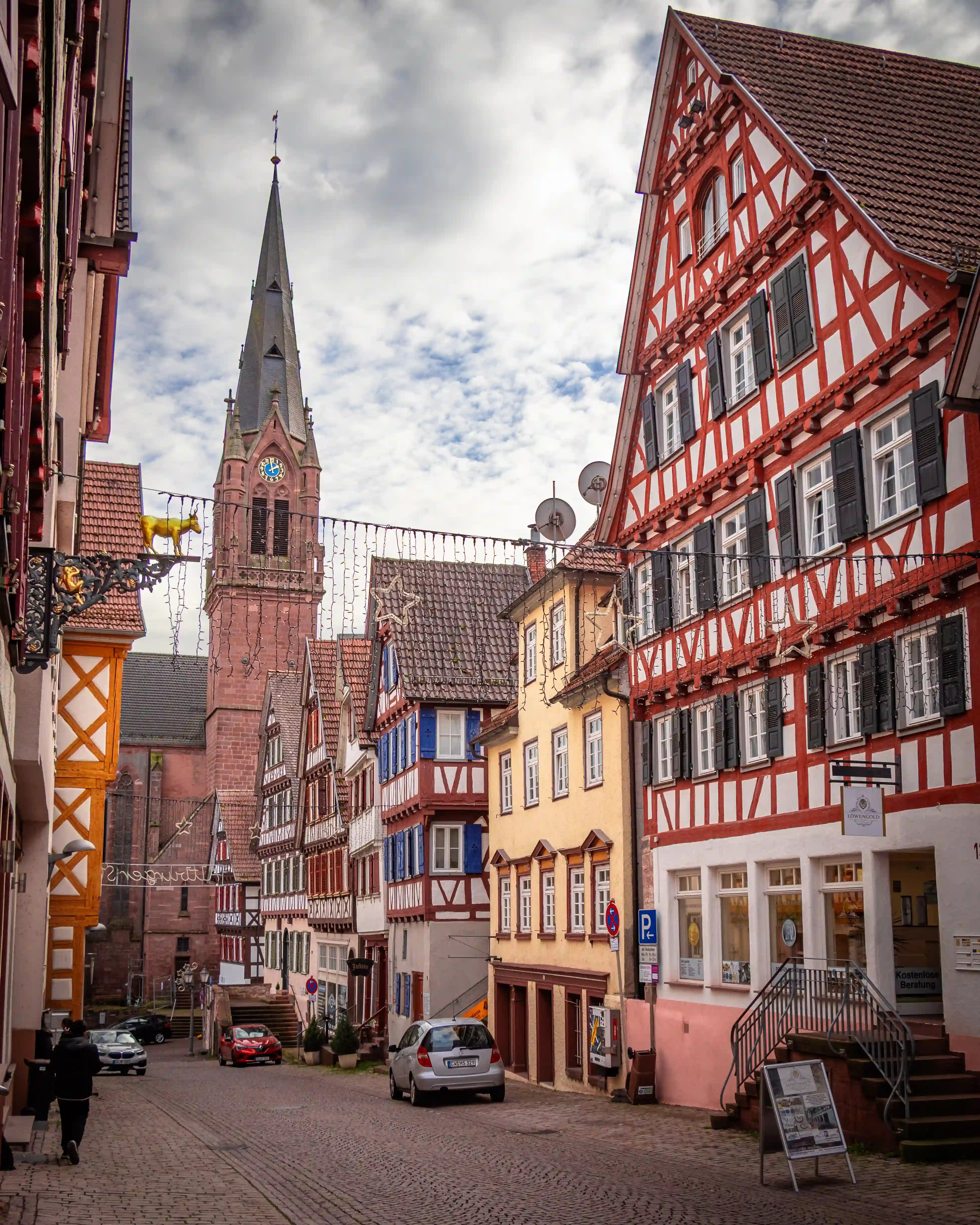 Stadtkirche St. Peter und Paul rises above a street lined with half-timbered houses in Calw.
