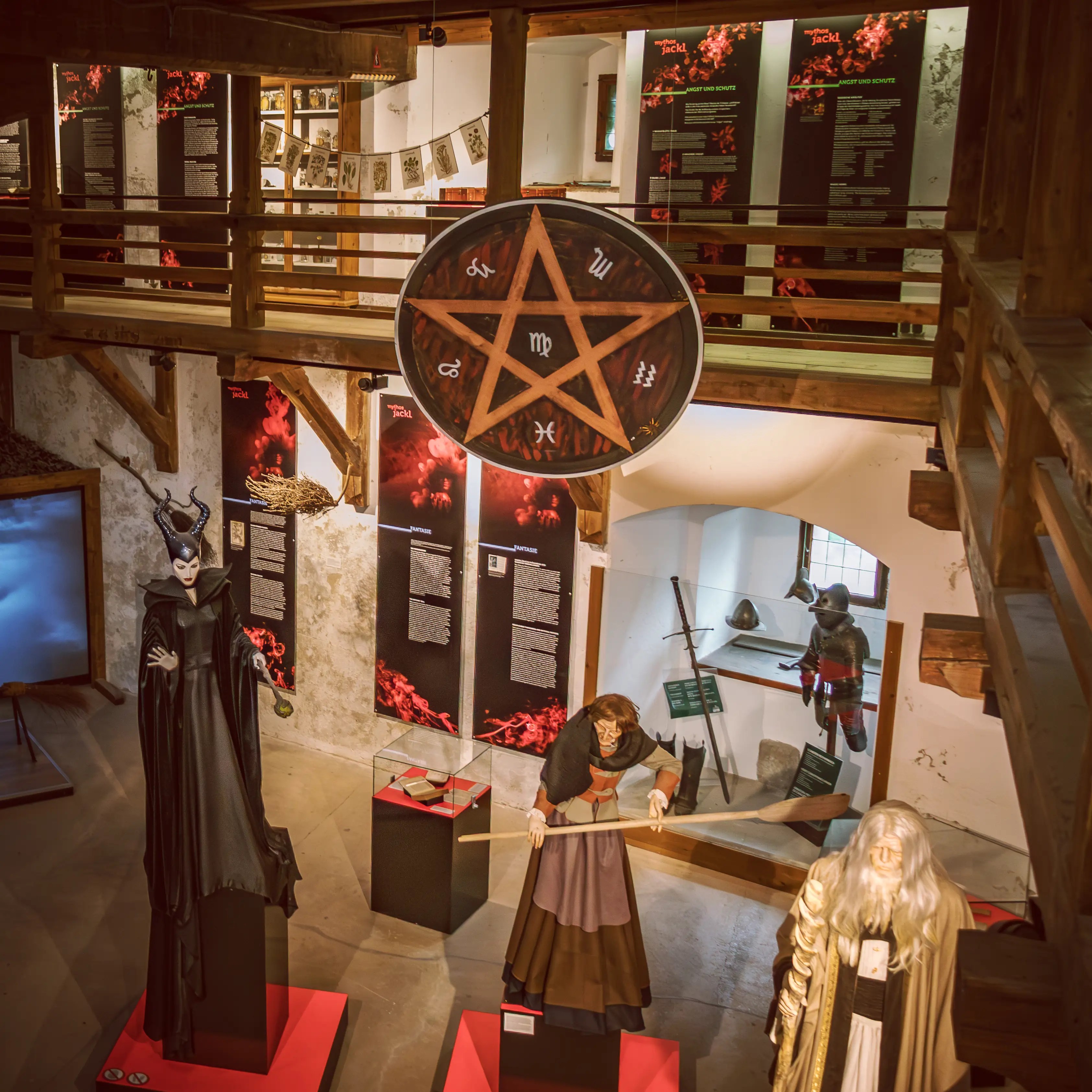 Life-sized figures stand beneath a large pentagram symbol inside a museum room at Burg Hohenwerfen.