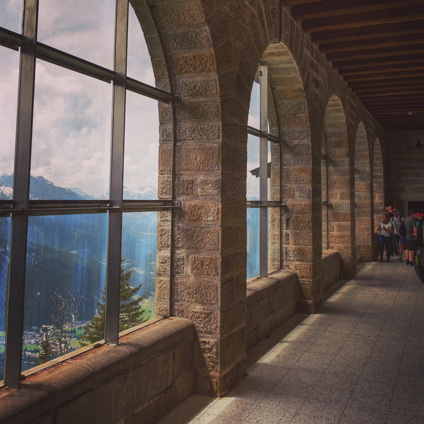 A stone corridor with arched windows overlooking alpine valleys inside the Eagle’s Nest.