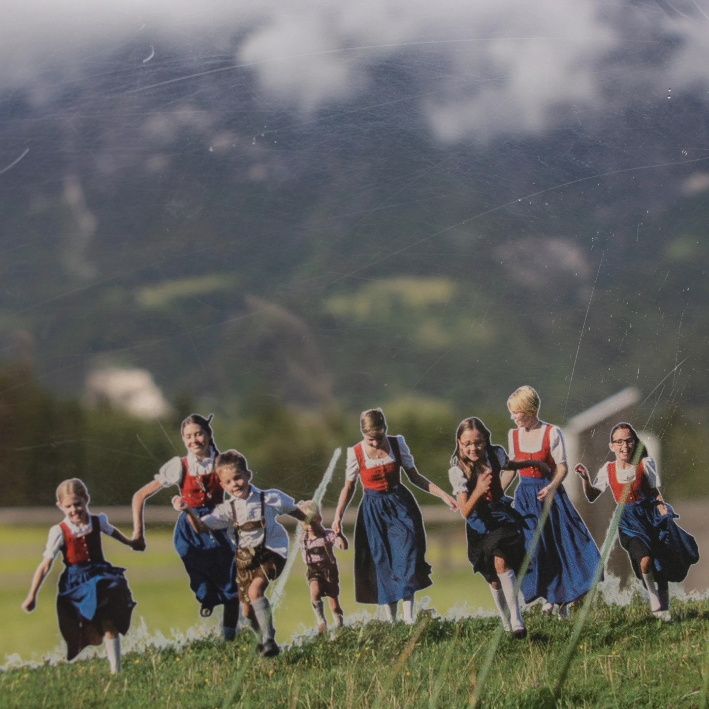 A display image shows children in traditional Austrian clothing running across a grassy meadow with mountains in the background.