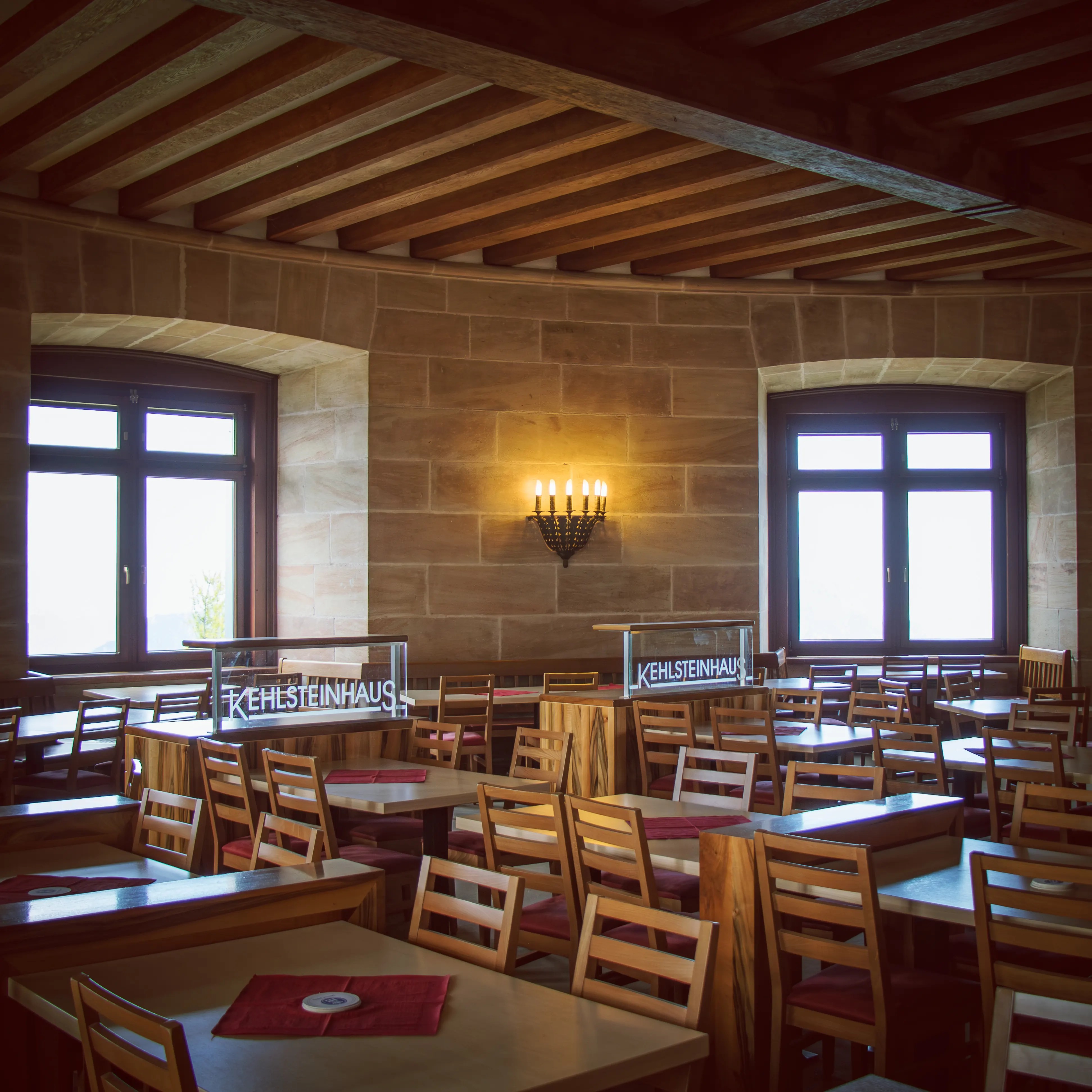 A dining room with wooden tables and chairs beneath exposed beams inside the Eagle’s Nest.