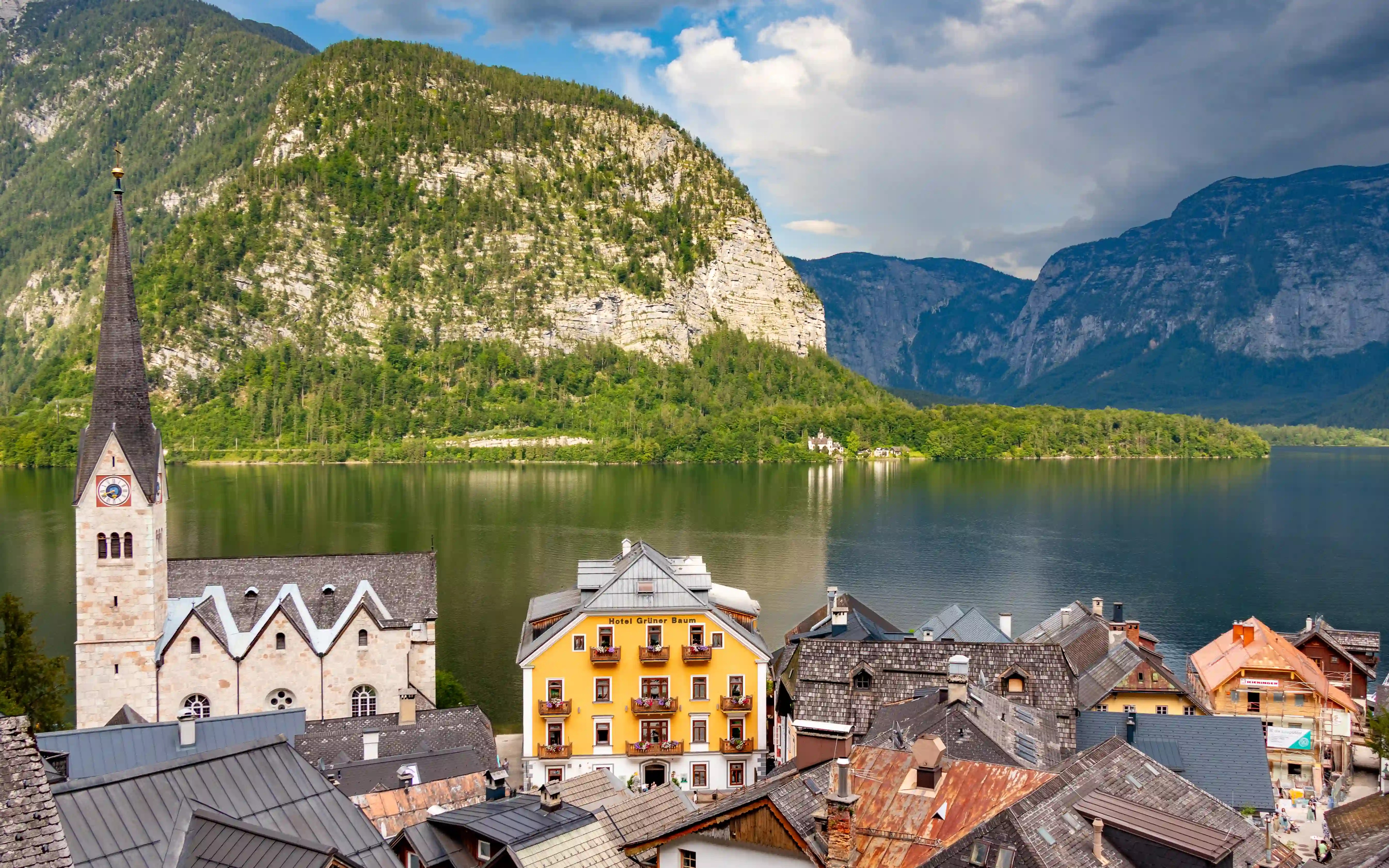 Hallstatt rooftops with the church and Hotel Grüner Baum visible along the lakeshore.