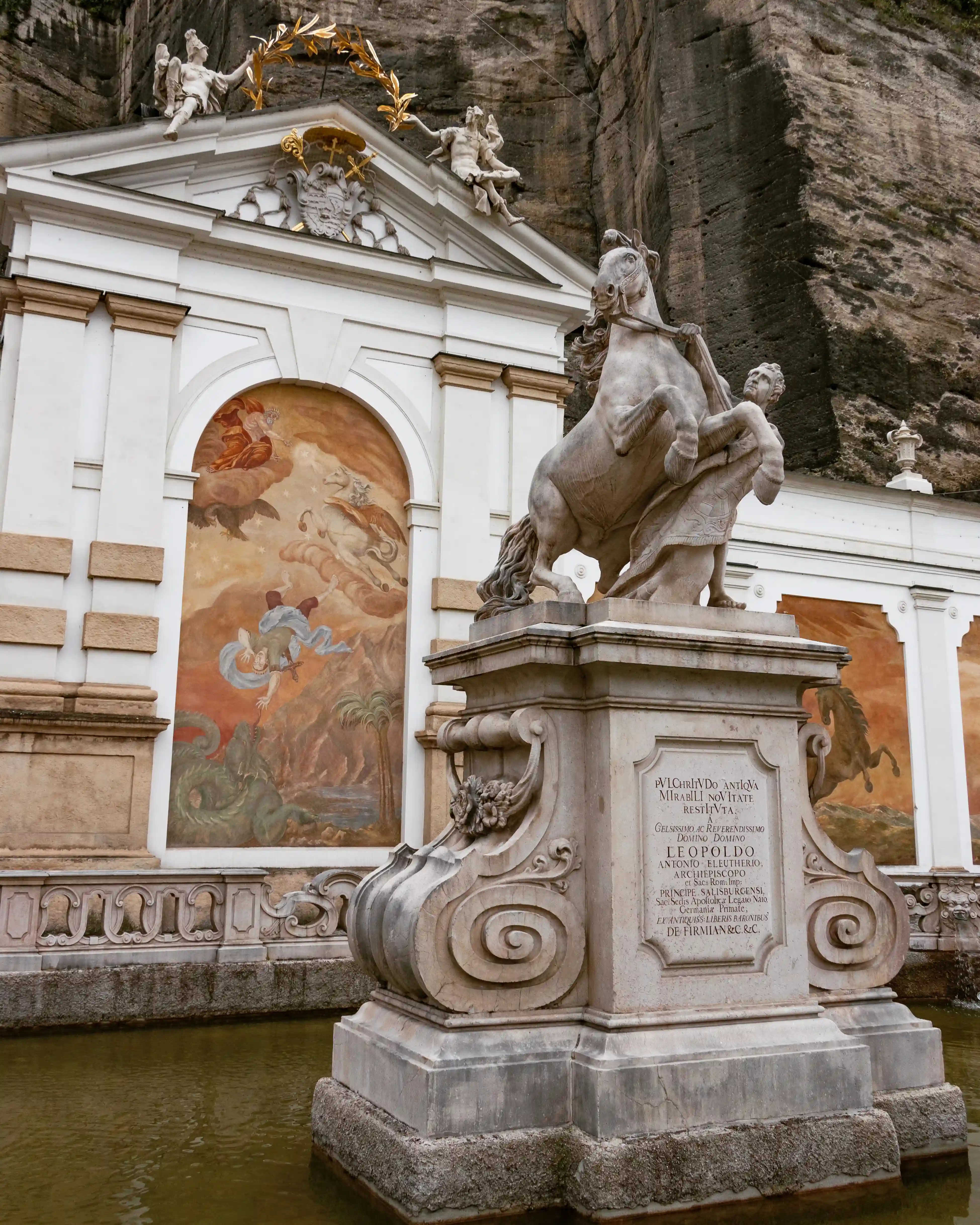 Baroque stone sculpture of a rearing horse and a kneeling figure at the Pferdeschwemme horse well in Salzburg.