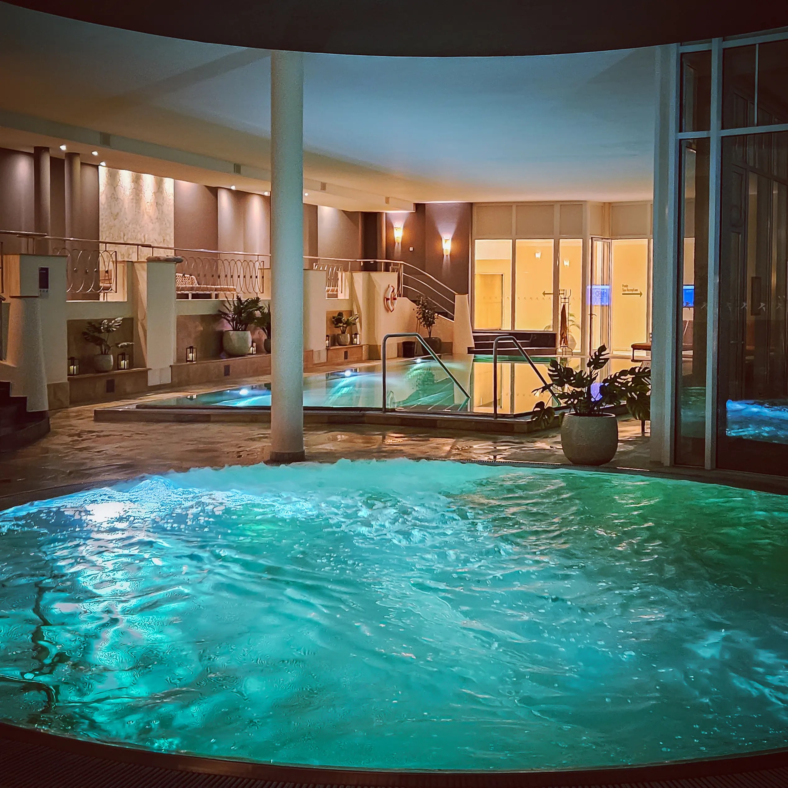 A bubbling whirlpool with glowing blue water inside the spa area of Falkensteiner Spa Resort.