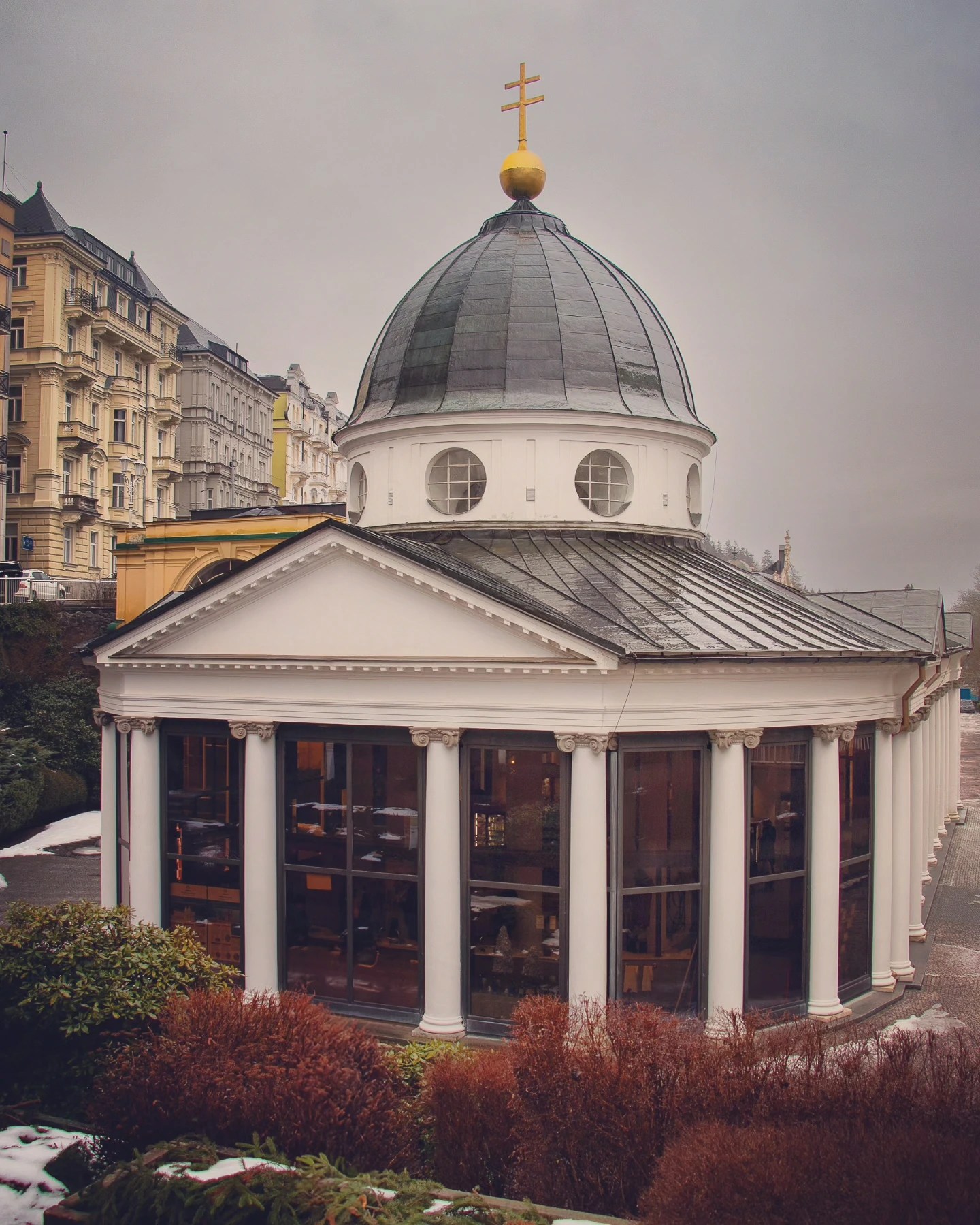The domed Cross Spring pavilion section of the Main Colonnade with white columns and a gold cross on top in Mariánské Lázně.