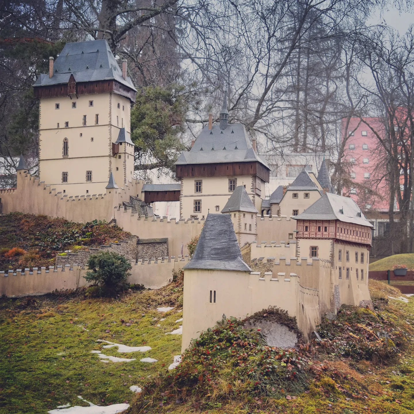 A large miniature fortified castle complex with walls, towers, and courtyards displayed in Park Boheminium.