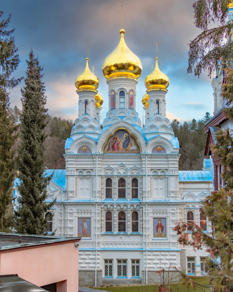 A view of the Orthodox Church of St. Peter and Paul in Karlovy Vary with multiple gold domes and religious icon mosaics.