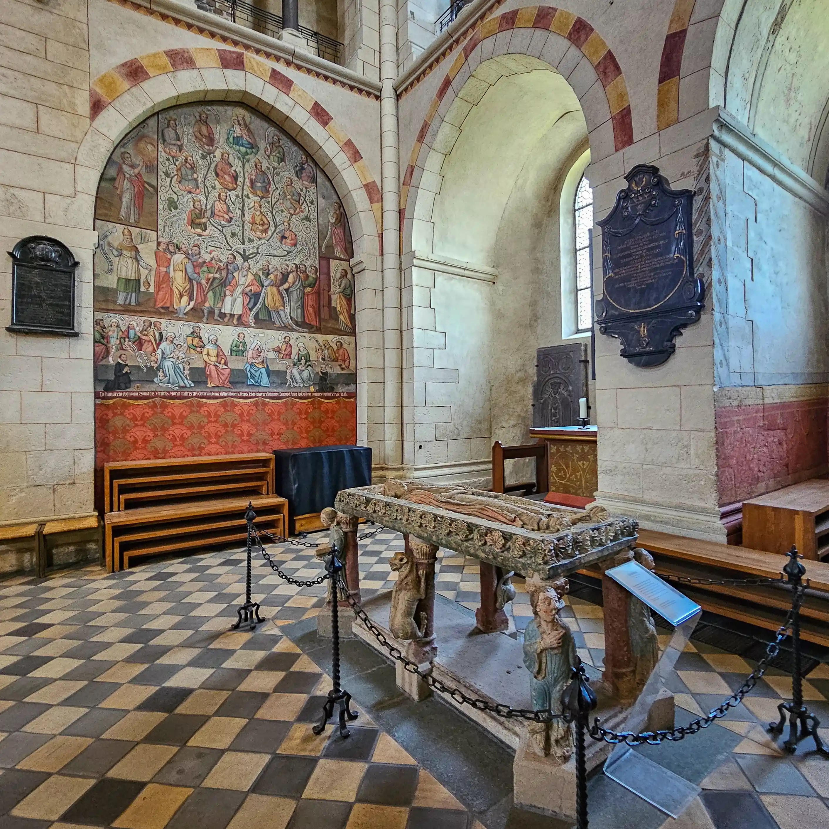 A wall painting, tomb, and checkered floor inside Limburger Dom in Limburg an der Lahn.