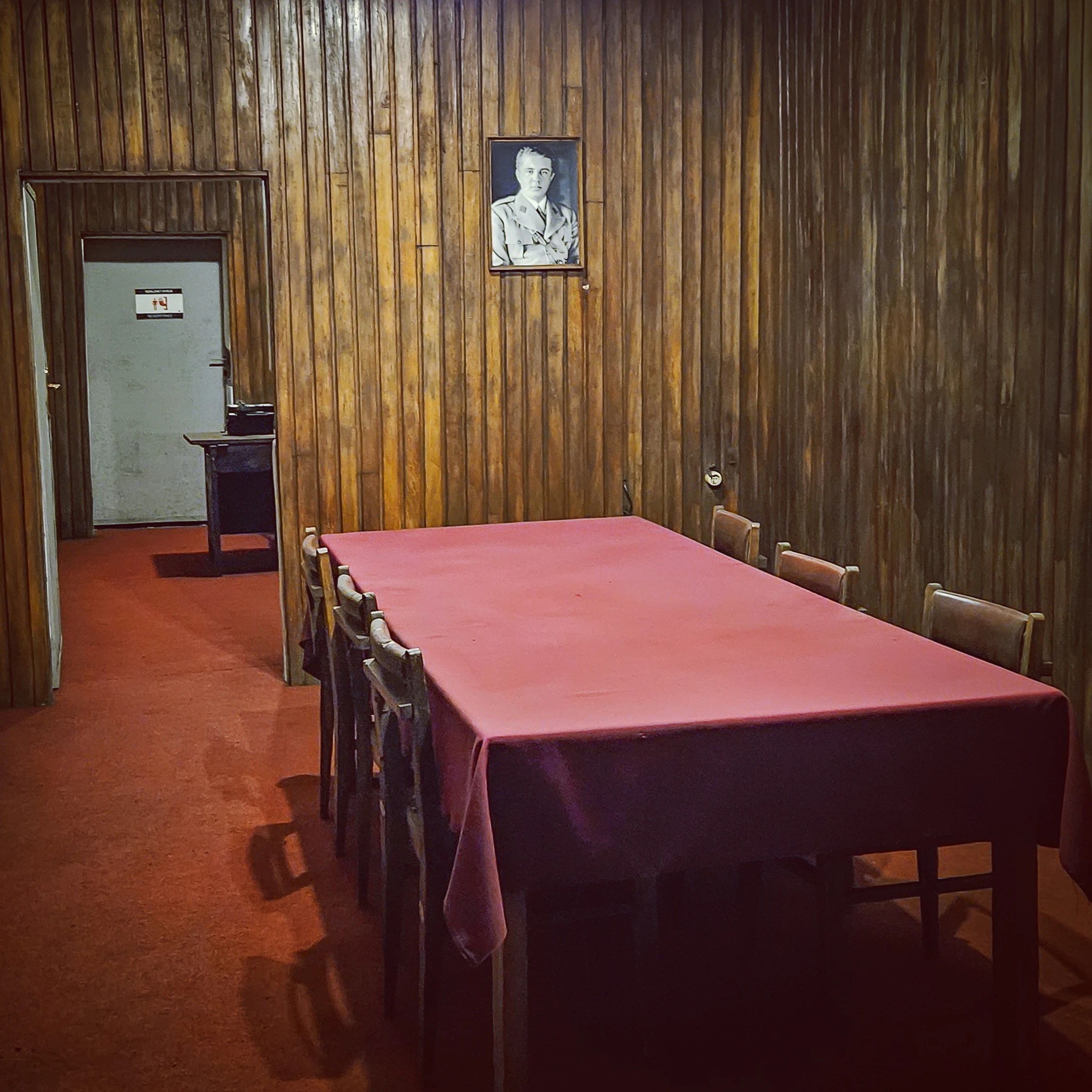 Wood-paneled conference room with a long table inside the underground bunker at Bunk'Art 1.