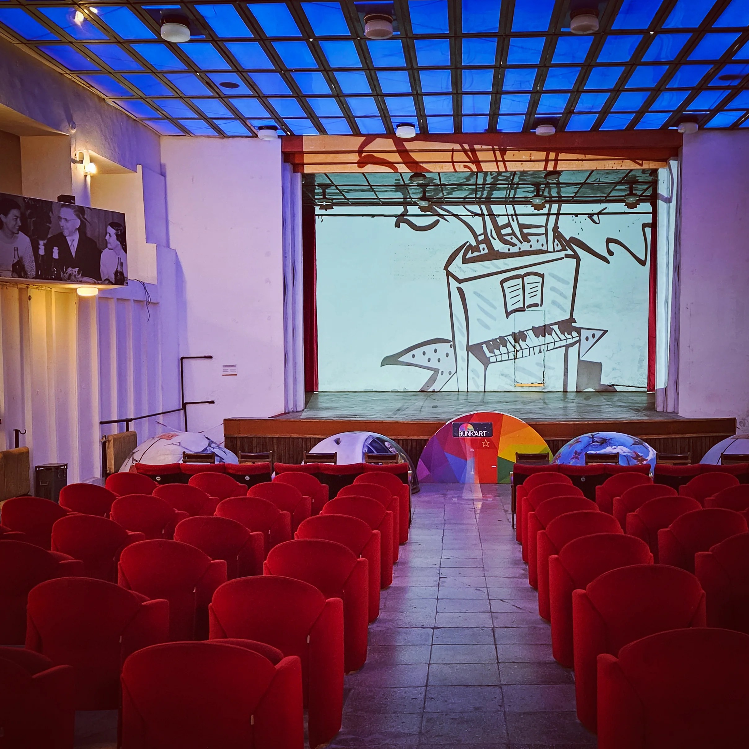 Auditorium with red seats and a stage inside Bunk'Art 1 in Tirana, Albania.