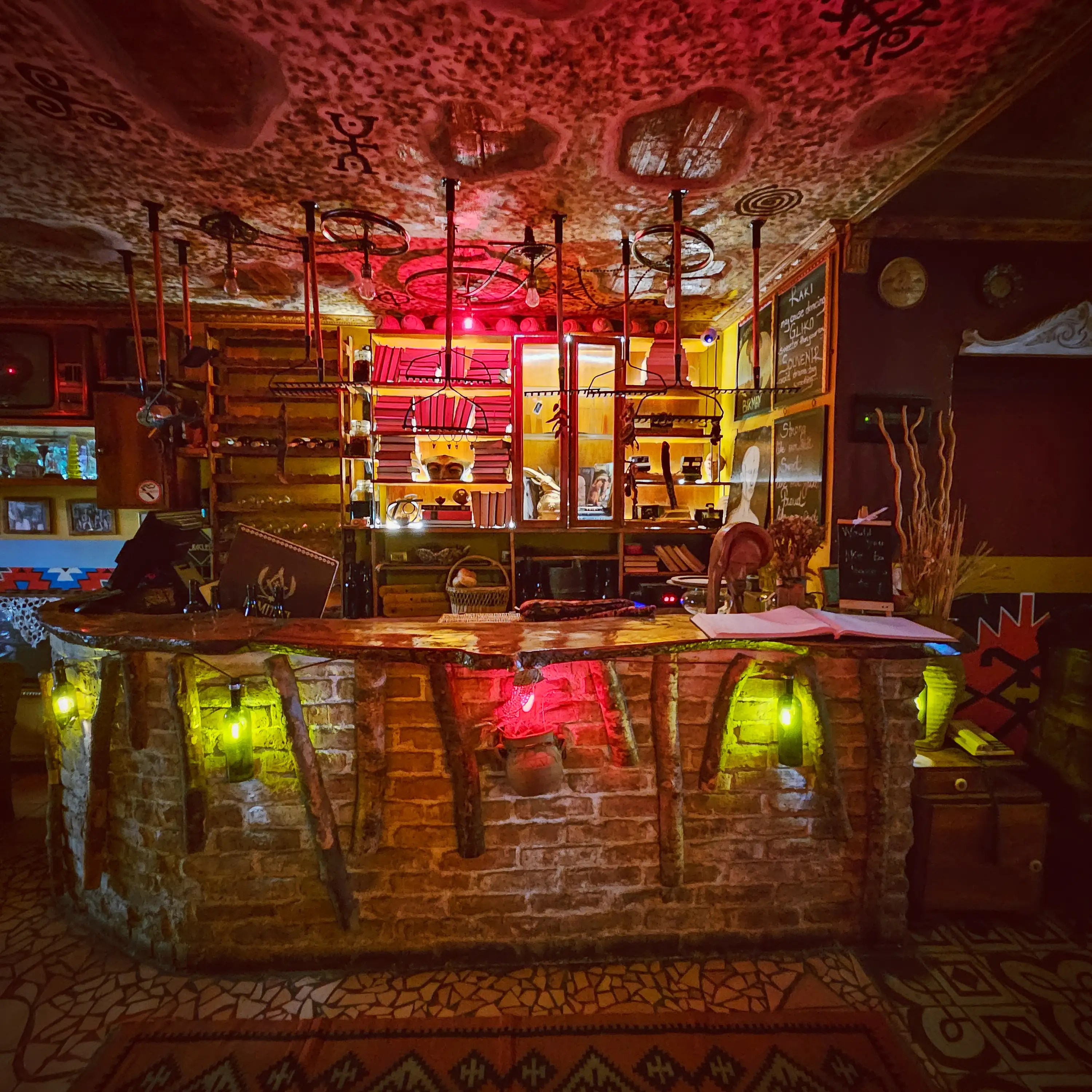 A warmly lit bar area filled with vintage objects, books, and traditional decorations inside Komiteti.