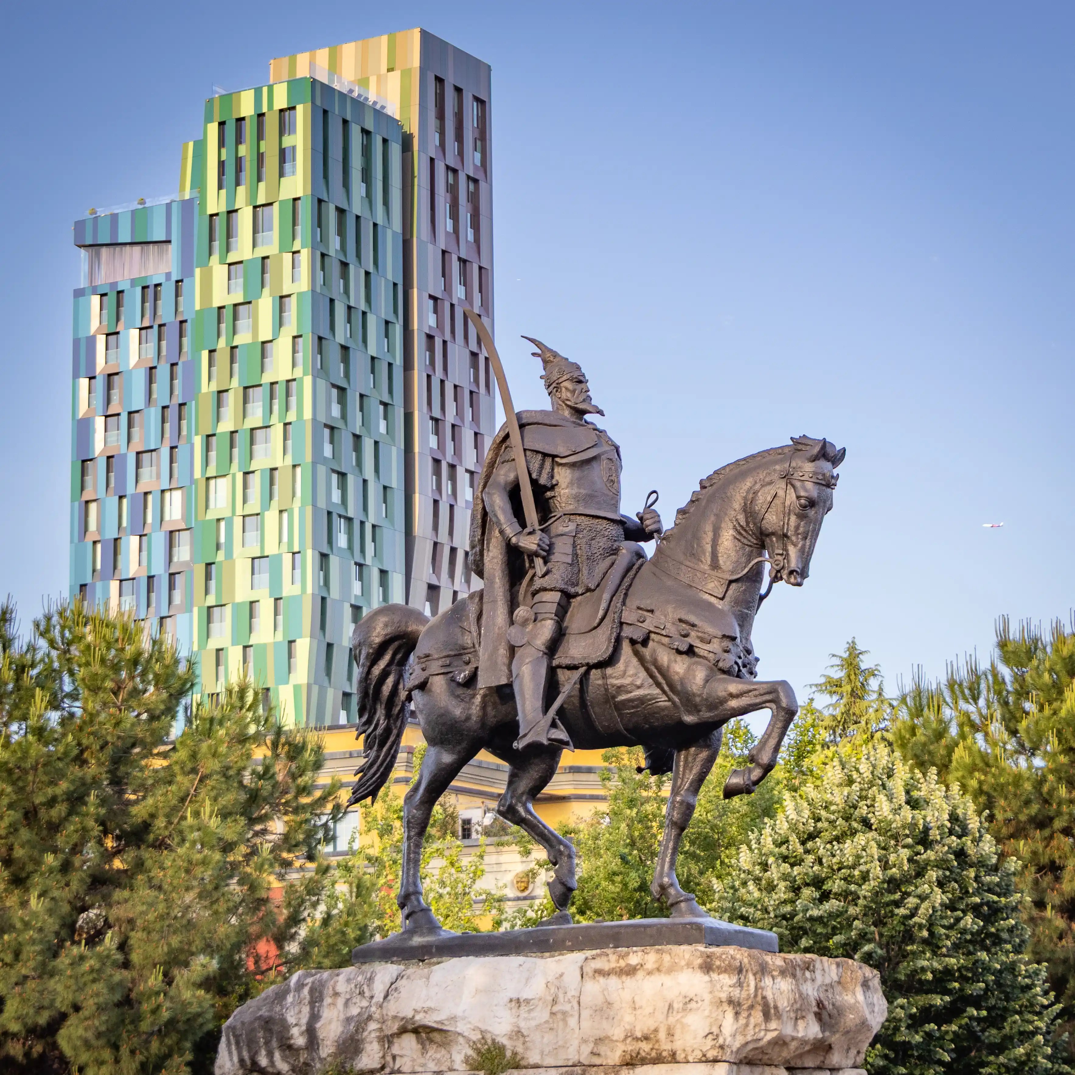 Equestrian statue of Skanderbeg with modern high-rise buildings in the background in Tirana, Albania.
