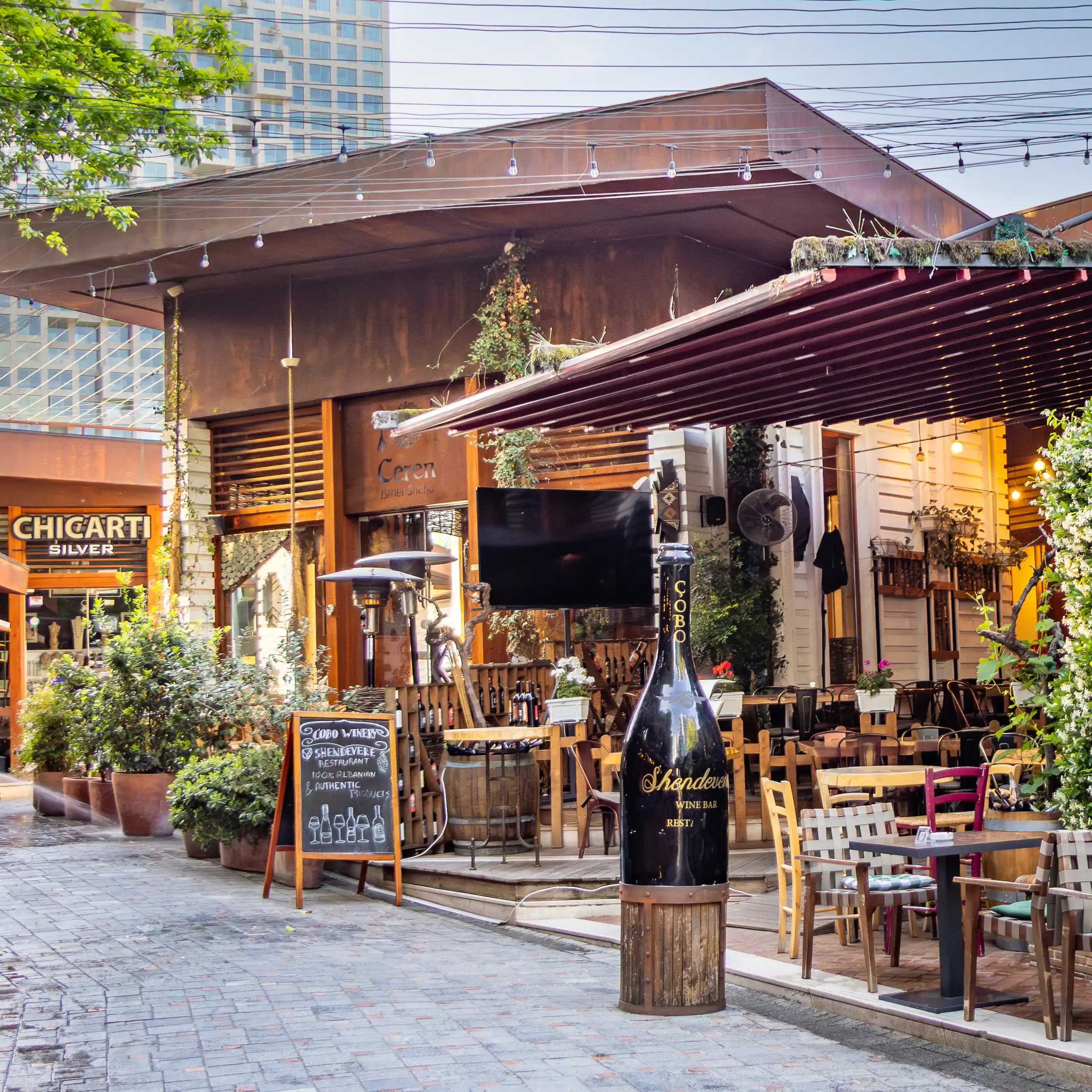 Restaurants and outdoor seating line a pedestrian street inside Tirana Castle.