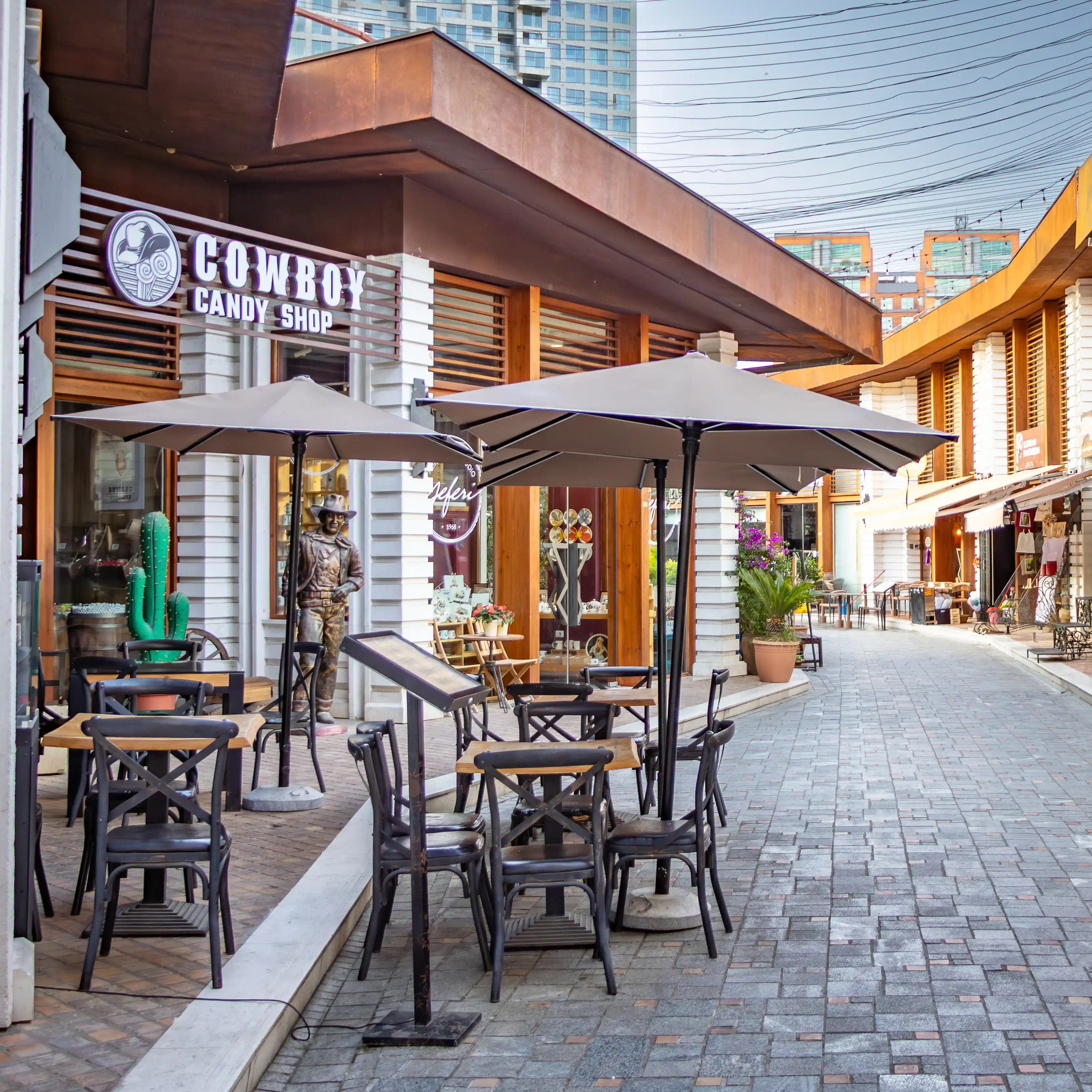 Outdoor tables and storefronts along a pedestrian lane inside Tirana Castle.