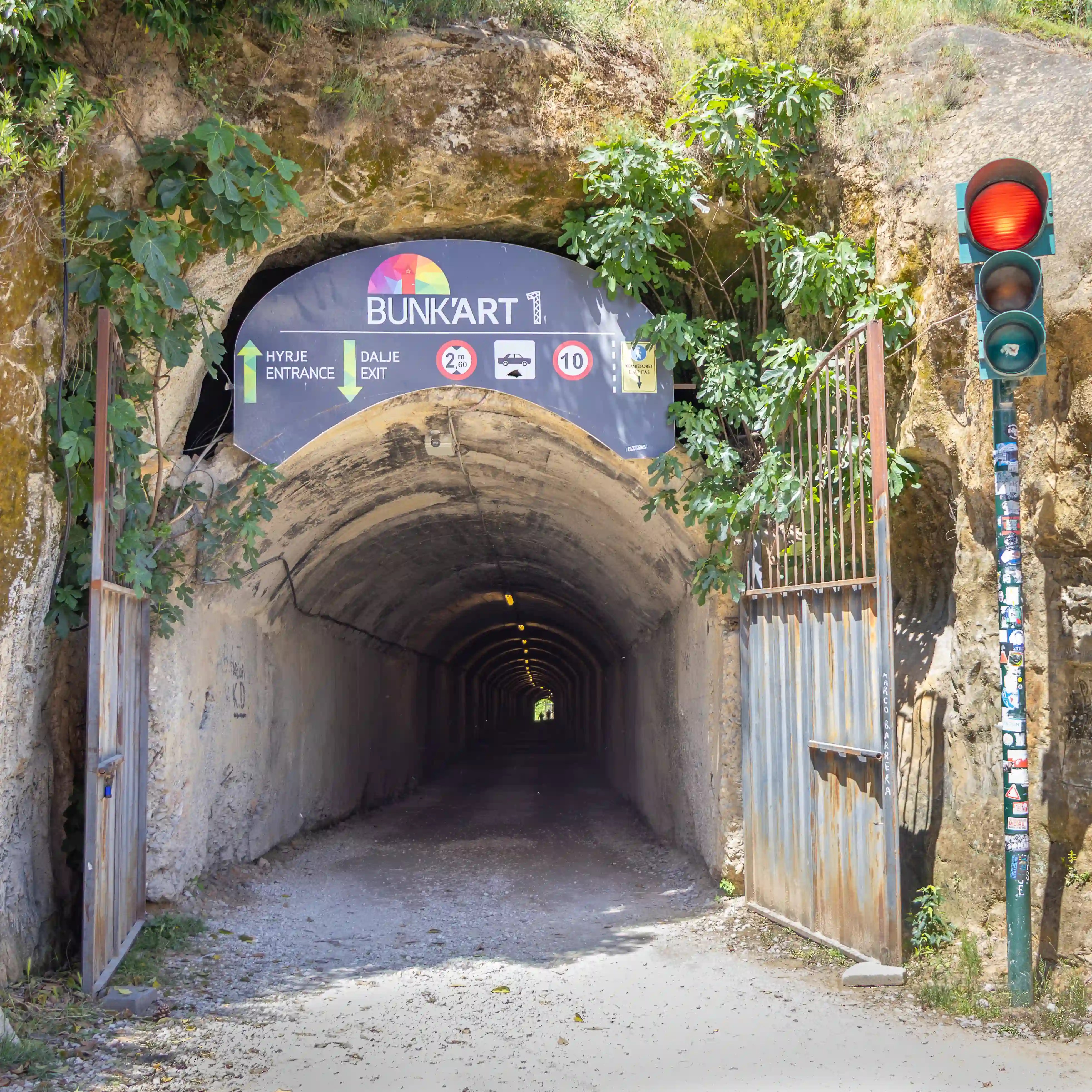 Entrance tunnel leading to Bunk'Art 1 in Tirana, Albania with a red stop light next to it.