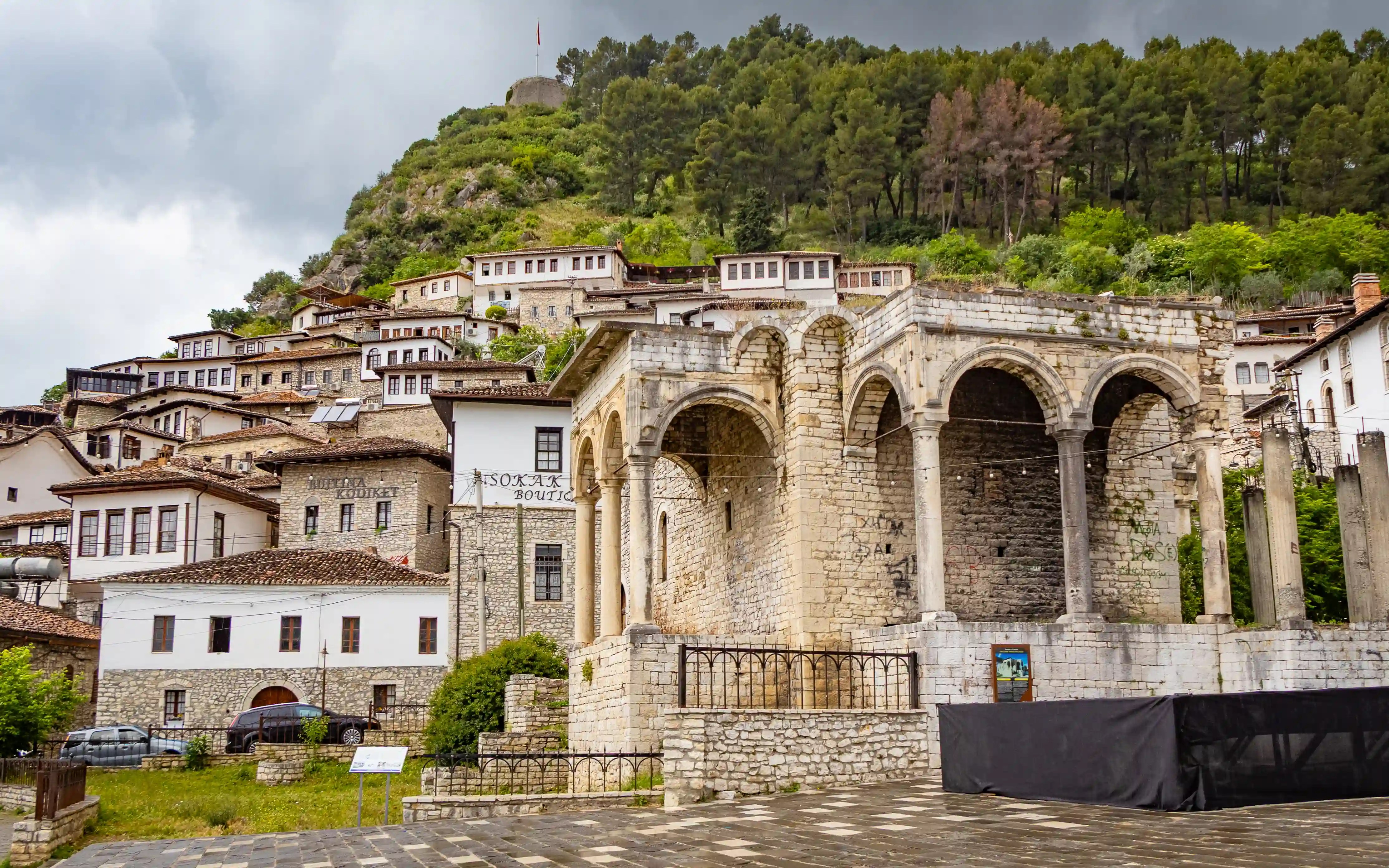 The ruins of the former Vrioni Palace stand beneath the hillside homes of Berat's Mangalem Quarter.