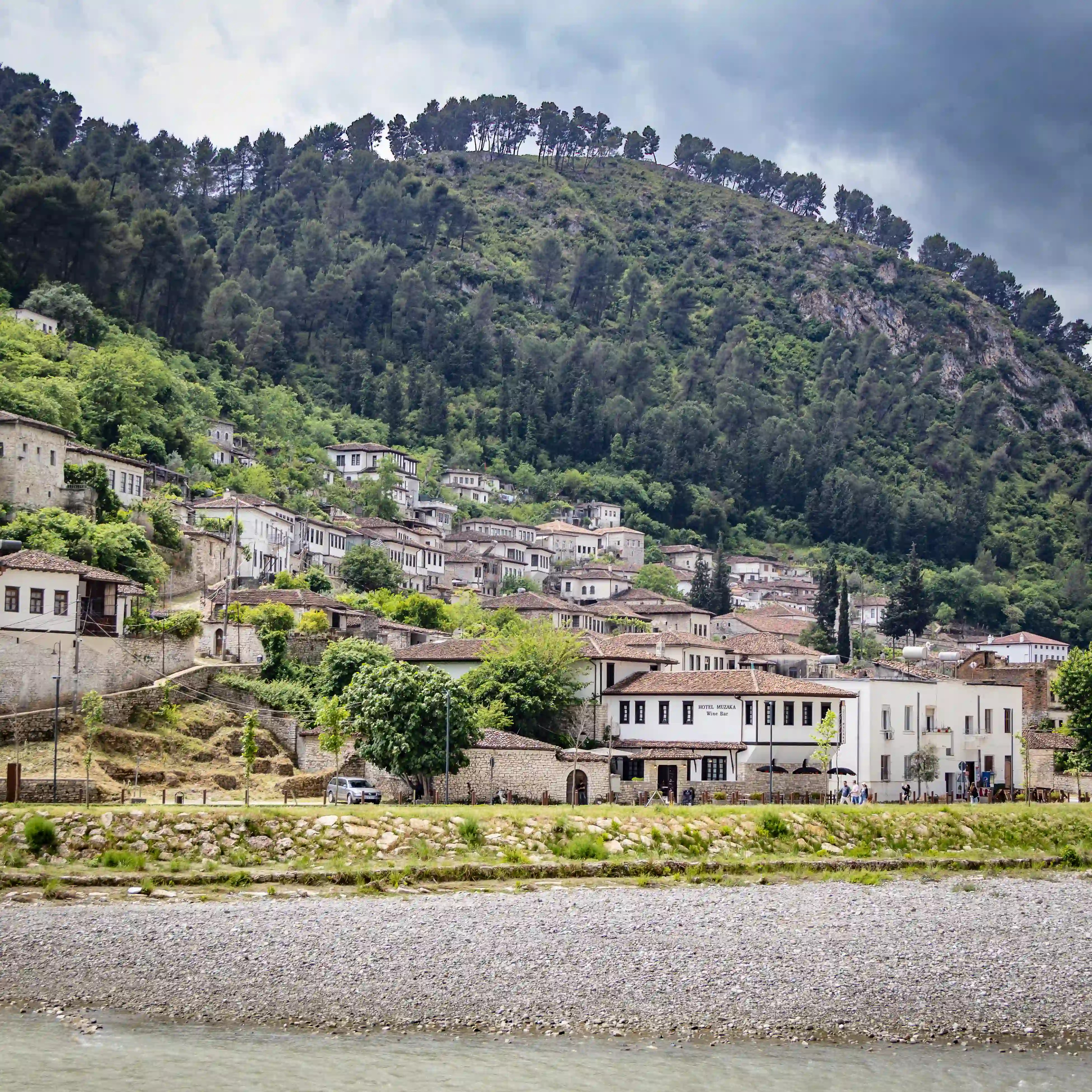 Historic stone and whitewashed houses line the hillside above the Osum River in Berat's Gorica Quarter.