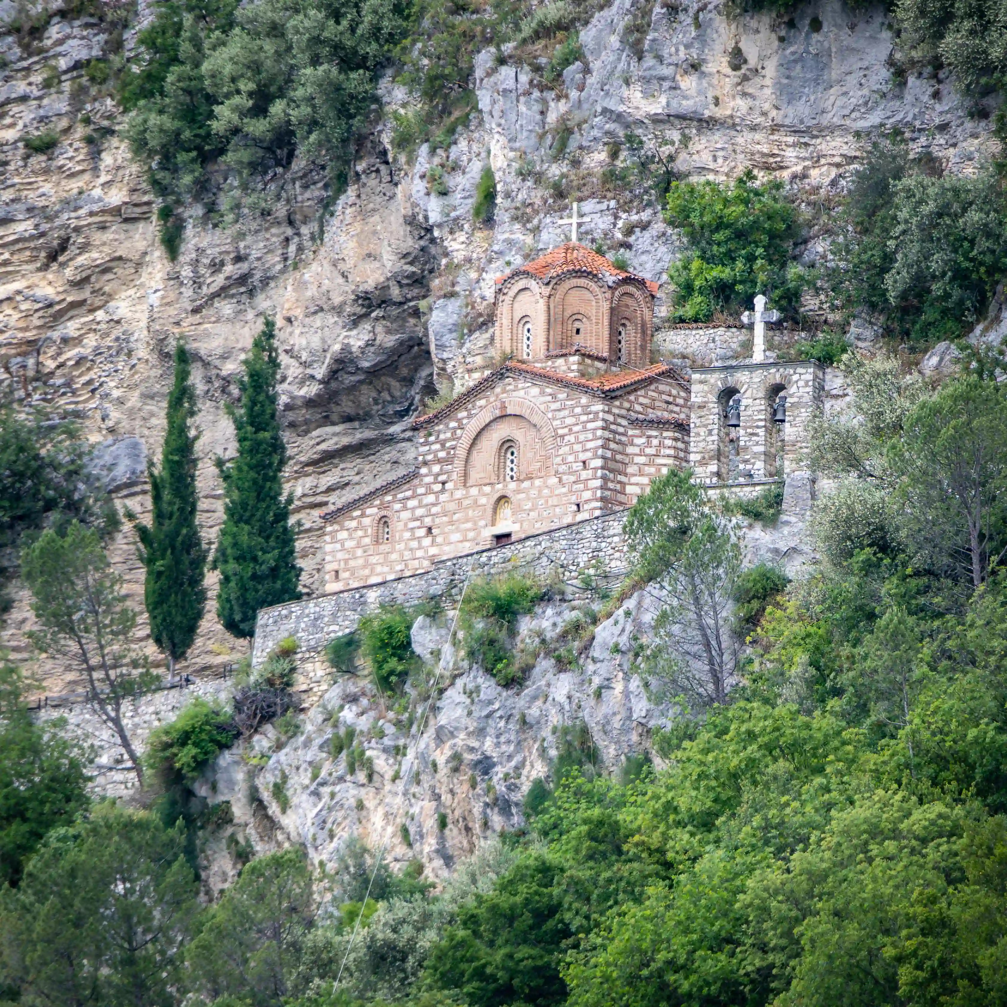 The Church of Saint Michael stands above the Osum River on a wooded hillside in Berat.