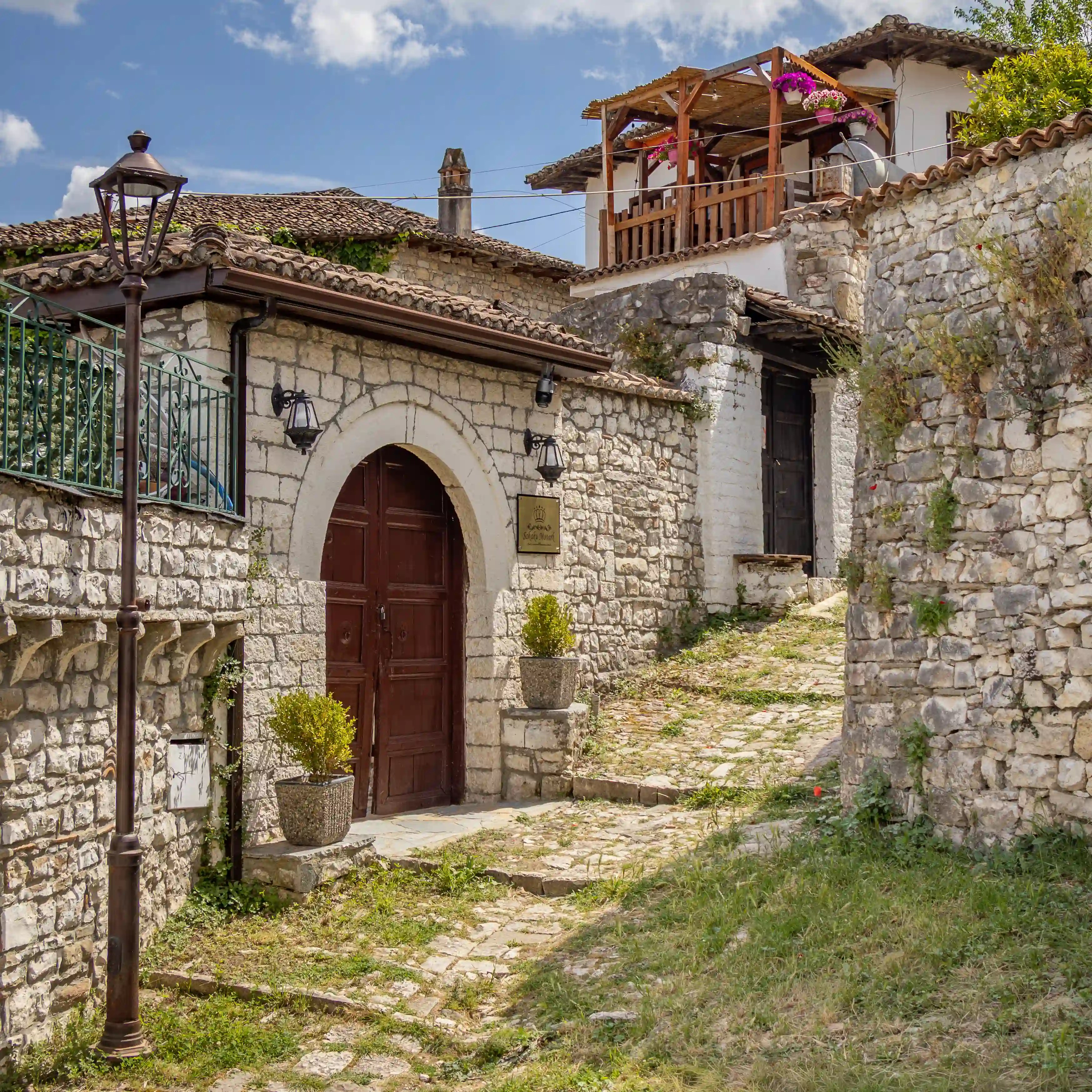 Stone lane lined with historic houses inside Berat Castle.
