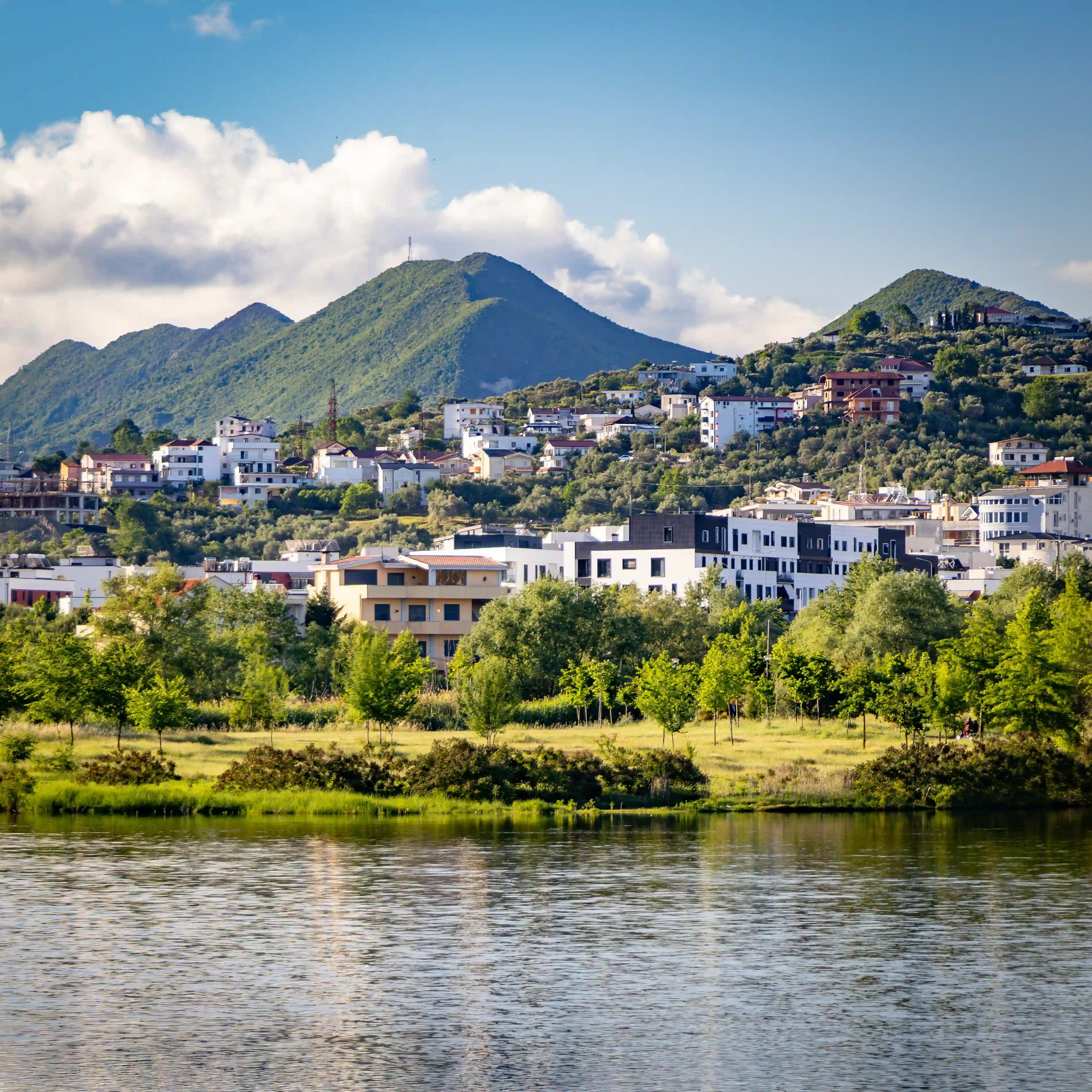 Green mountains and hillside homes overlooking Tirana's Artificial Lake.