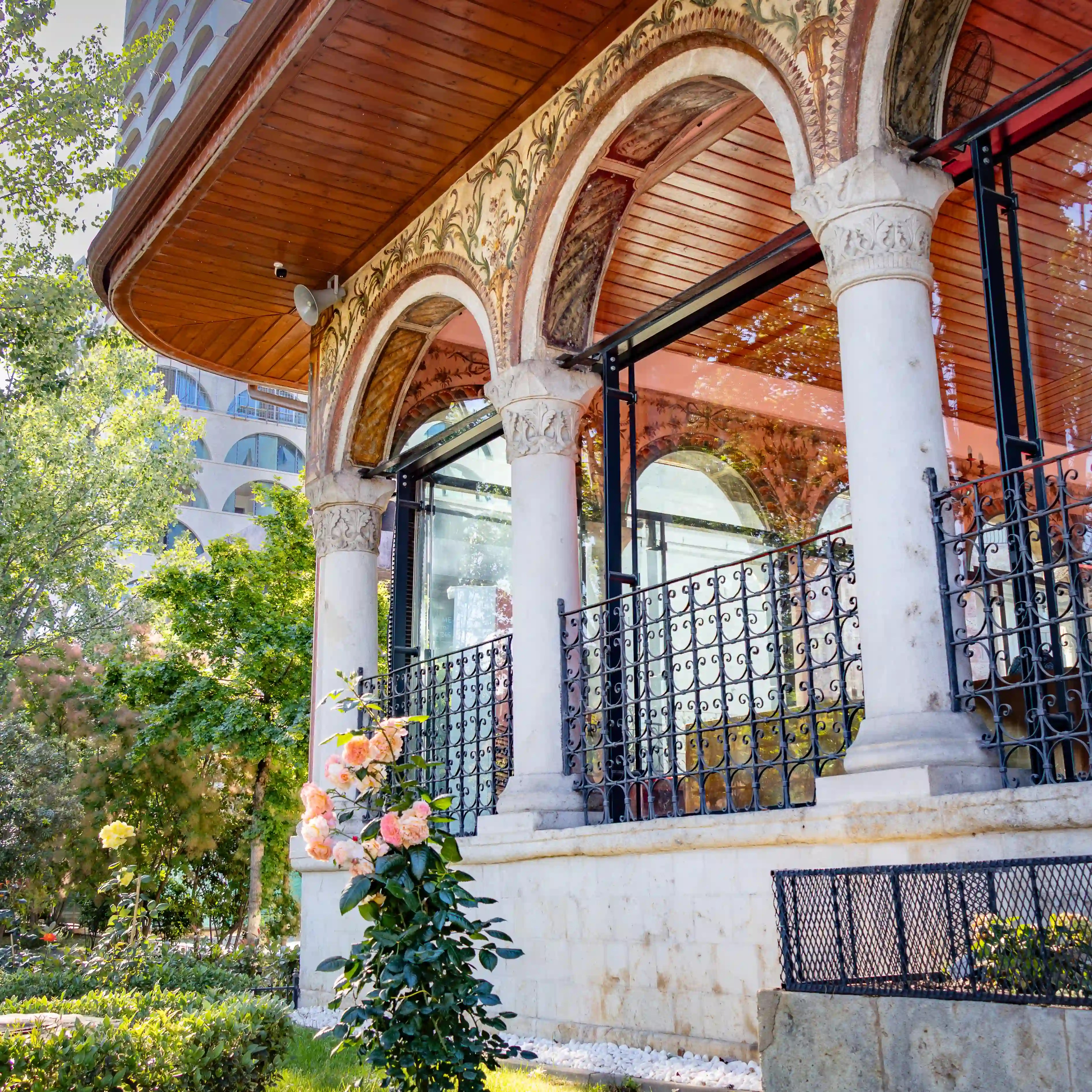 Arched portico with painted decorations and stone columns at the Et'hem Bej Mosque in Tirana.